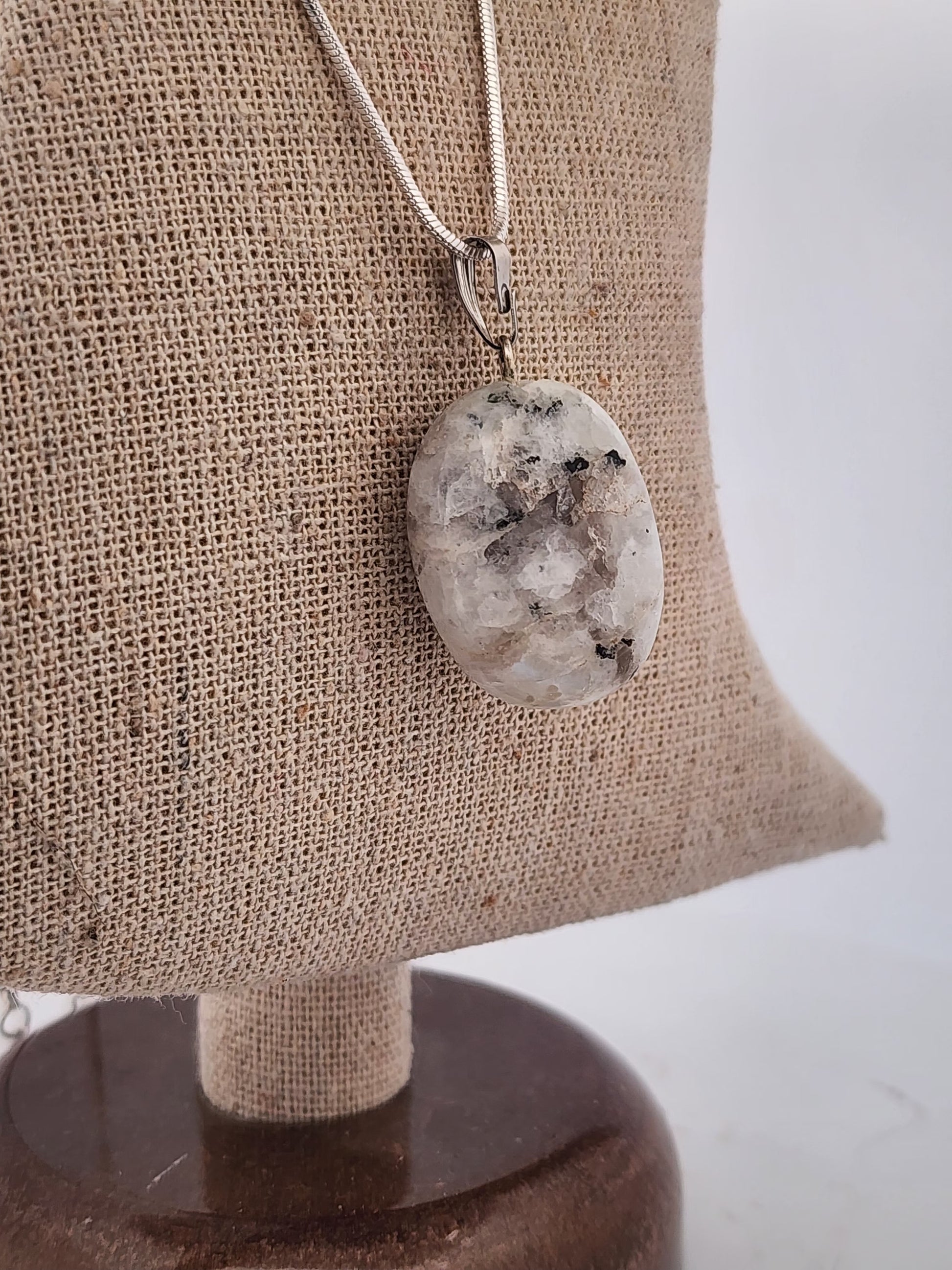 Necklace with a pendant on a mannequin bust against a plain background