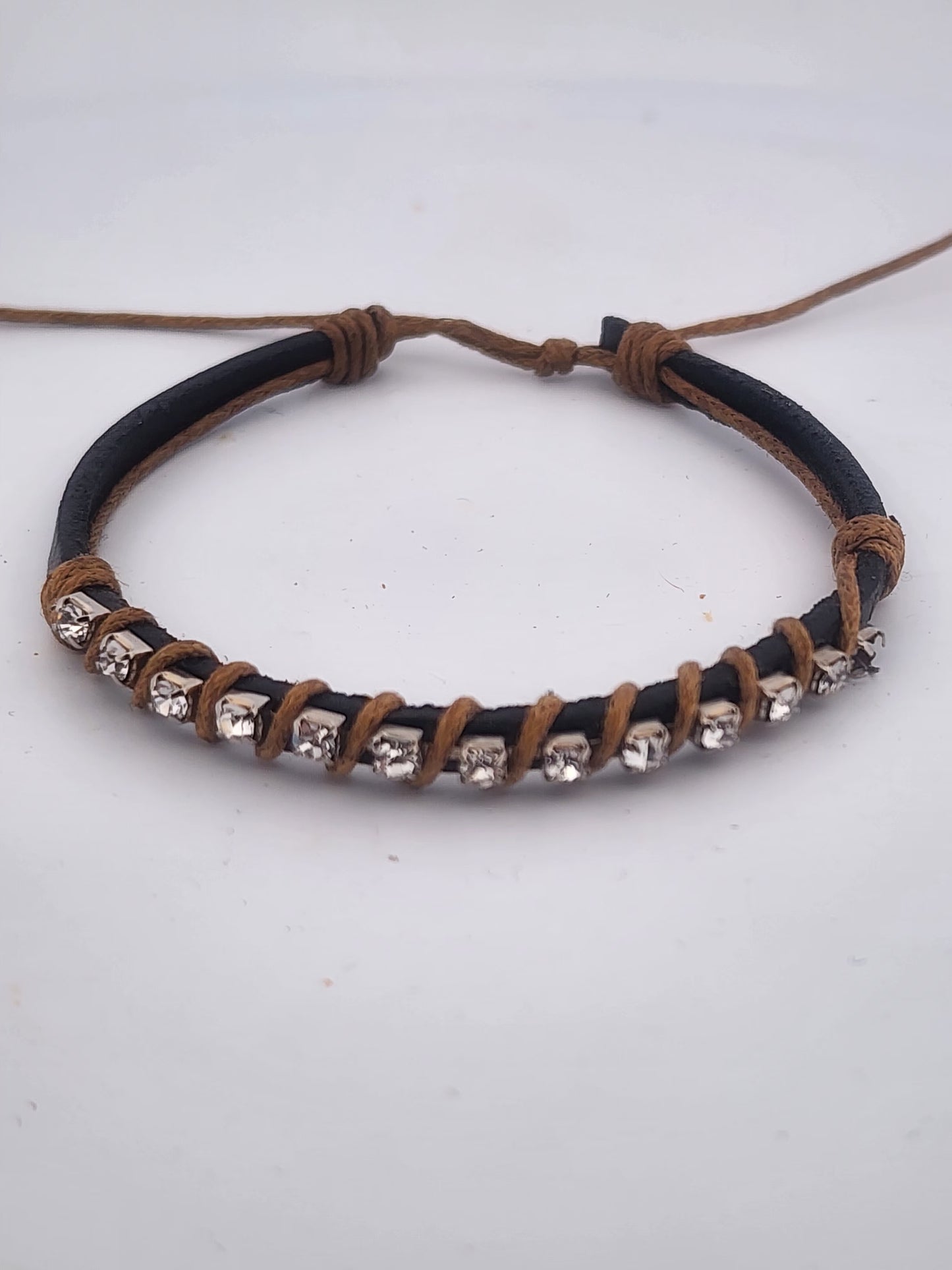 Bracelet with black and brown leather straps and silver beads on a white background