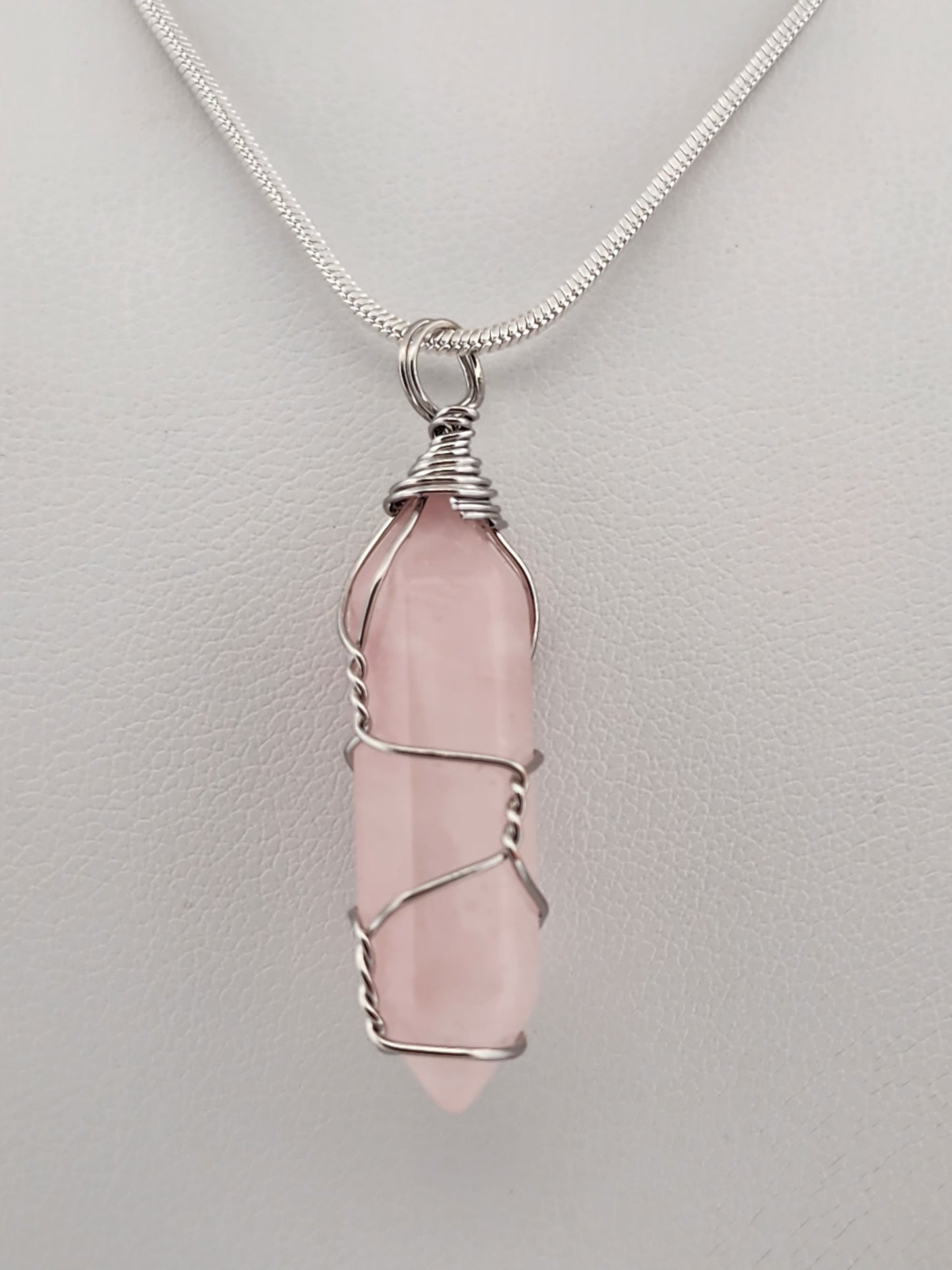Pink crystal pendant necklace on a light gray background