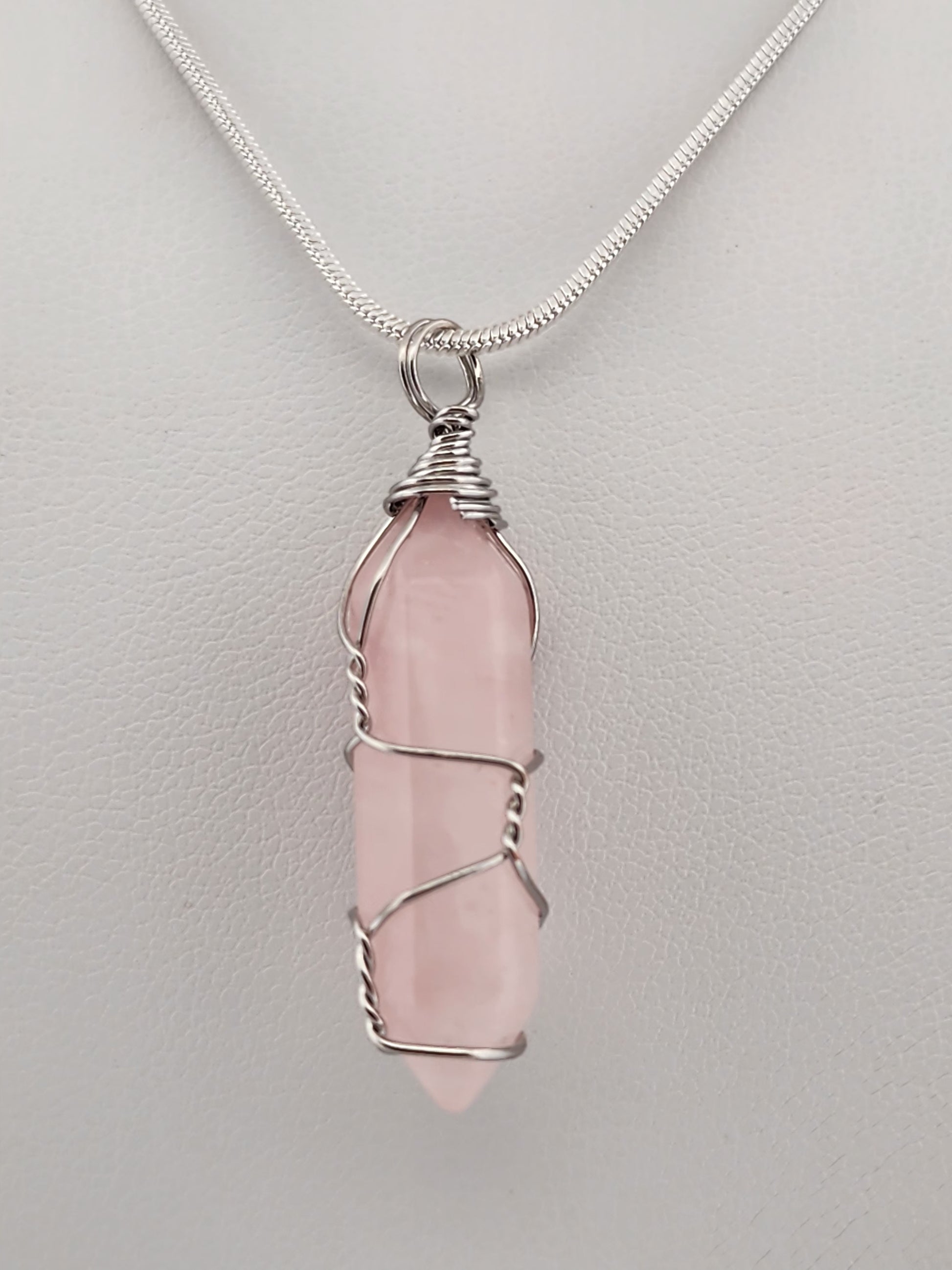 Pink crystal pendant necklace on a light gray background