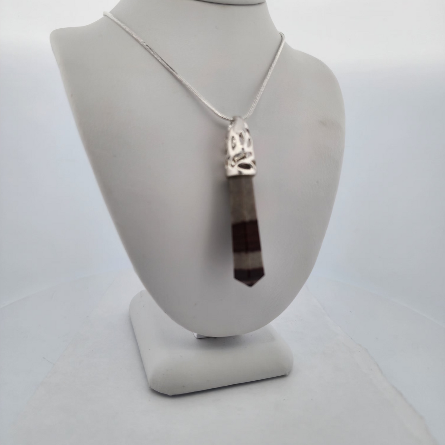 Necklace with a pendant on a mannequin bust against a white background