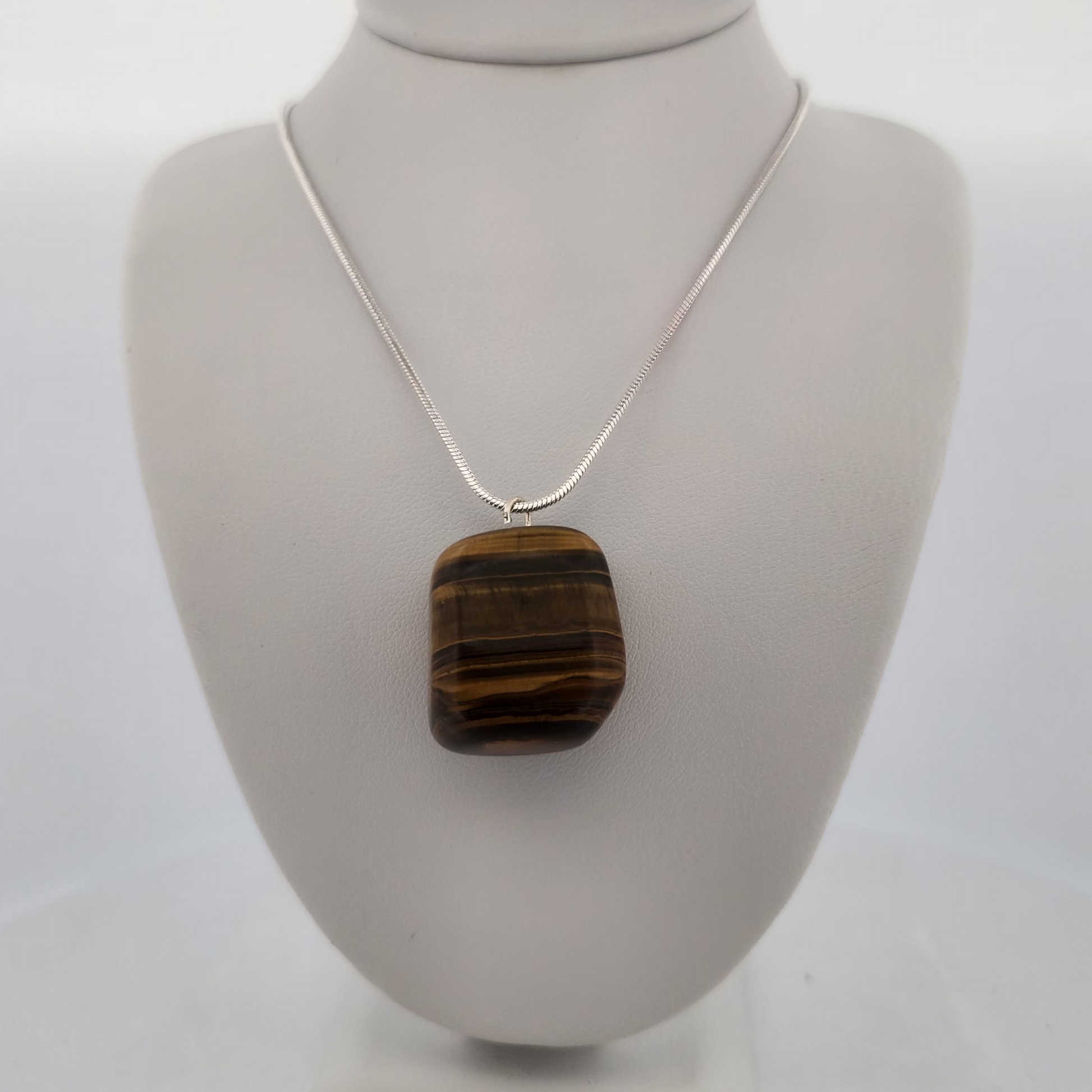 Necklace with a square brown pendant on a white mannequin bust.