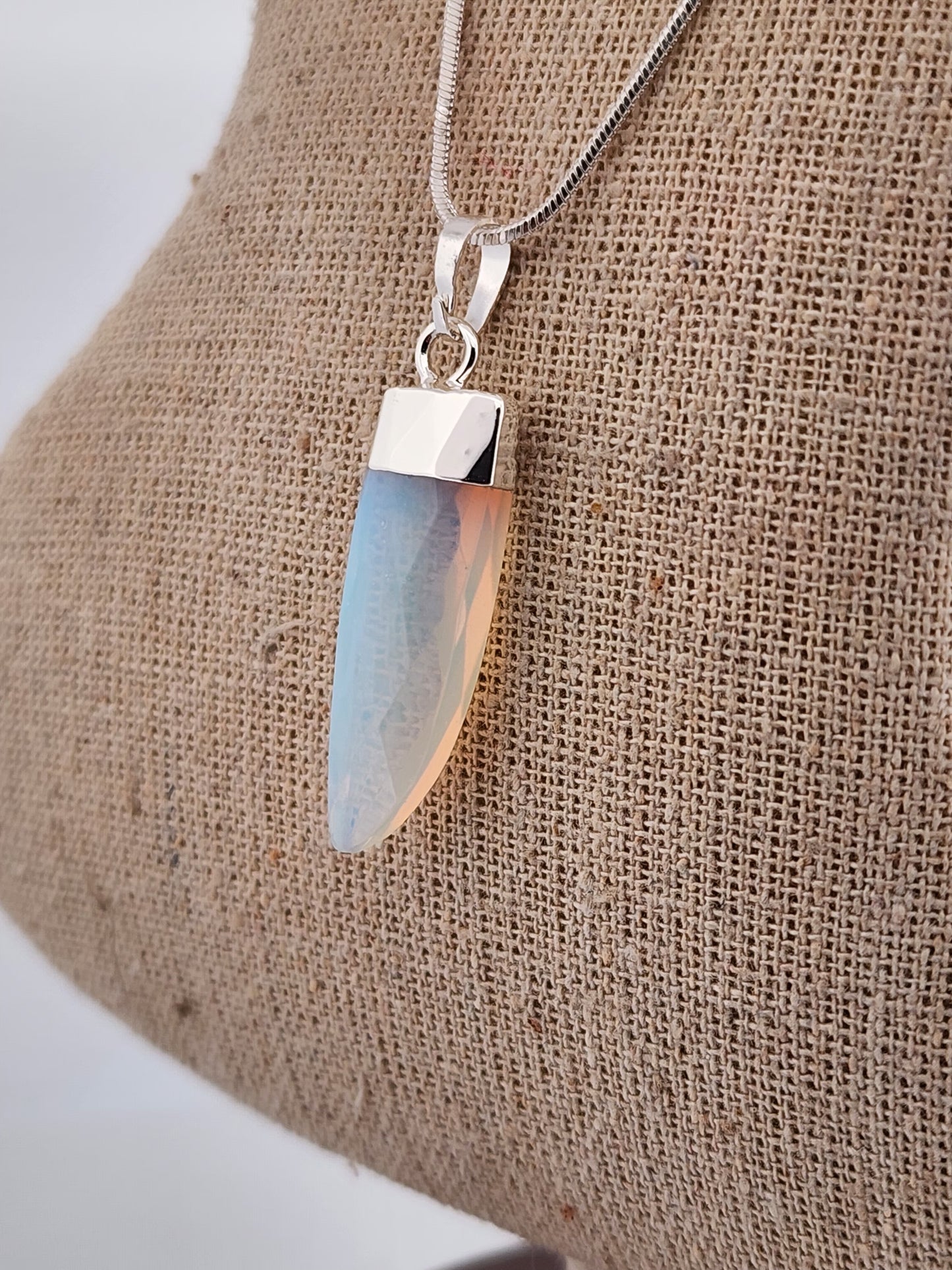 Necklace with a pendant on a textured beige surface
