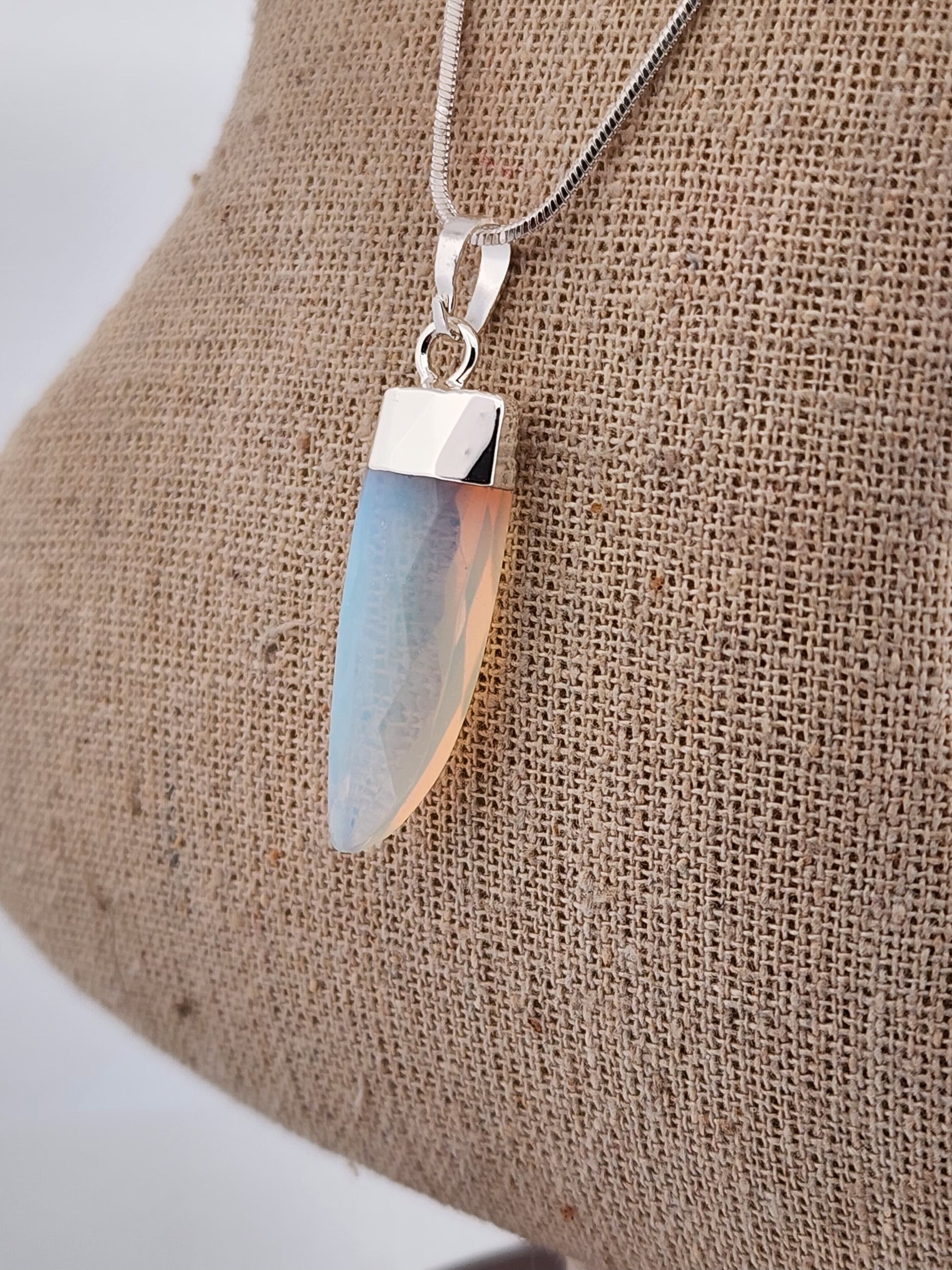 Necklace with a pendant on a textured beige surface
