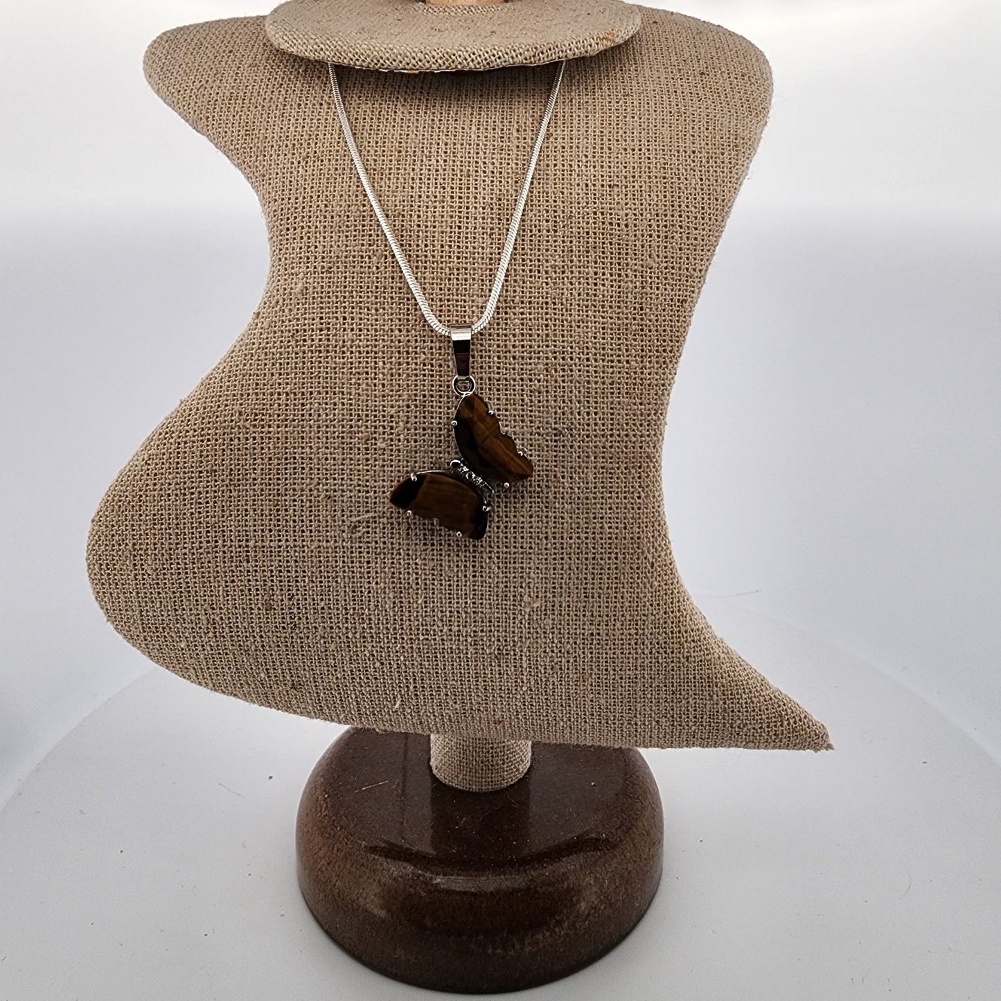 Necklace with a butterfly pendant on a mannequin bust against a white background