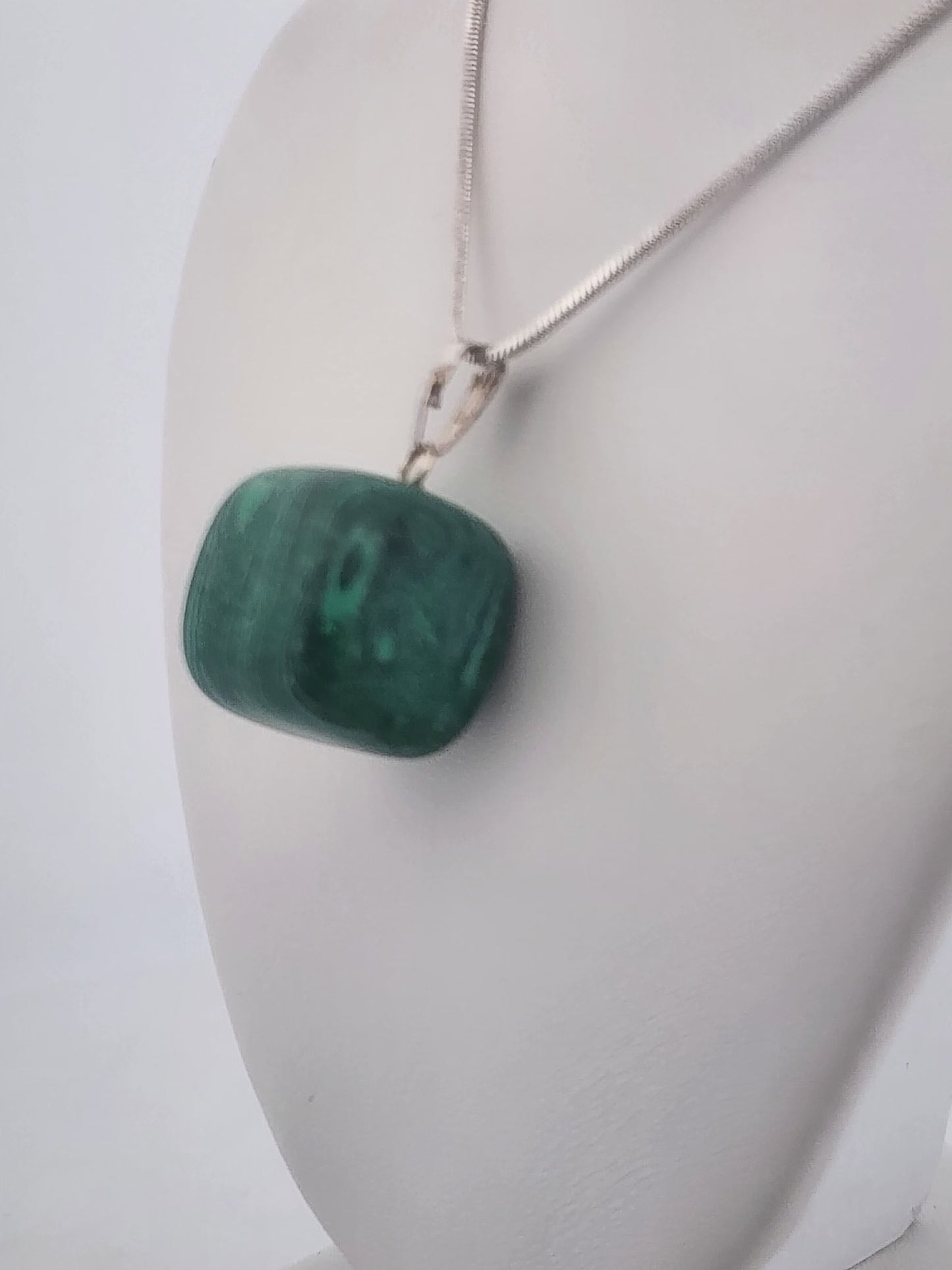 Green pendant necklace on a white mannequin bust