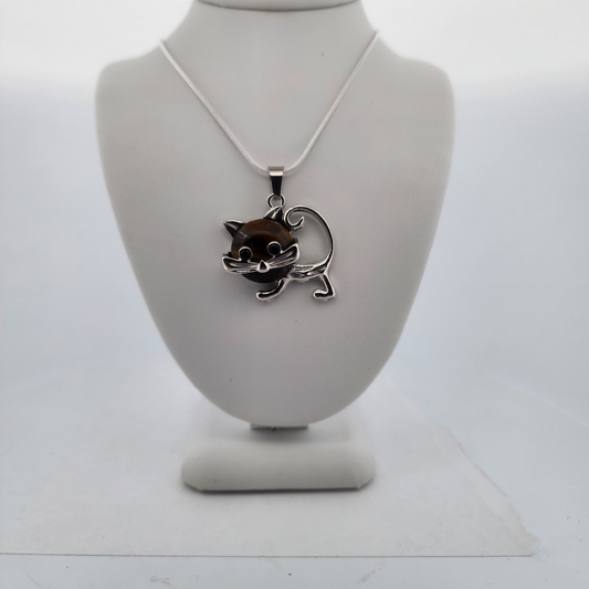 Silver necklace with a cat pendant on a white stand against a white background