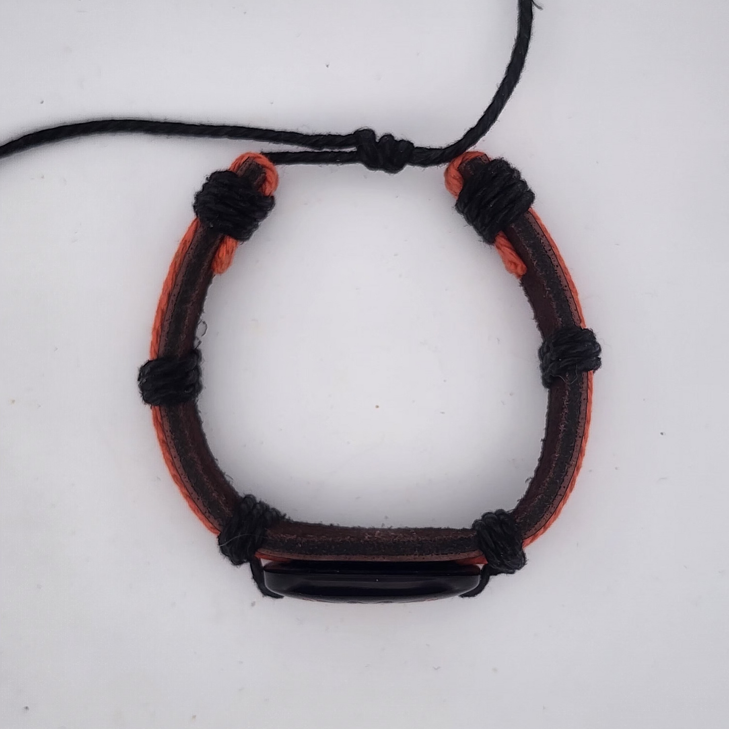 Bracelet with black and orange cord on a white background