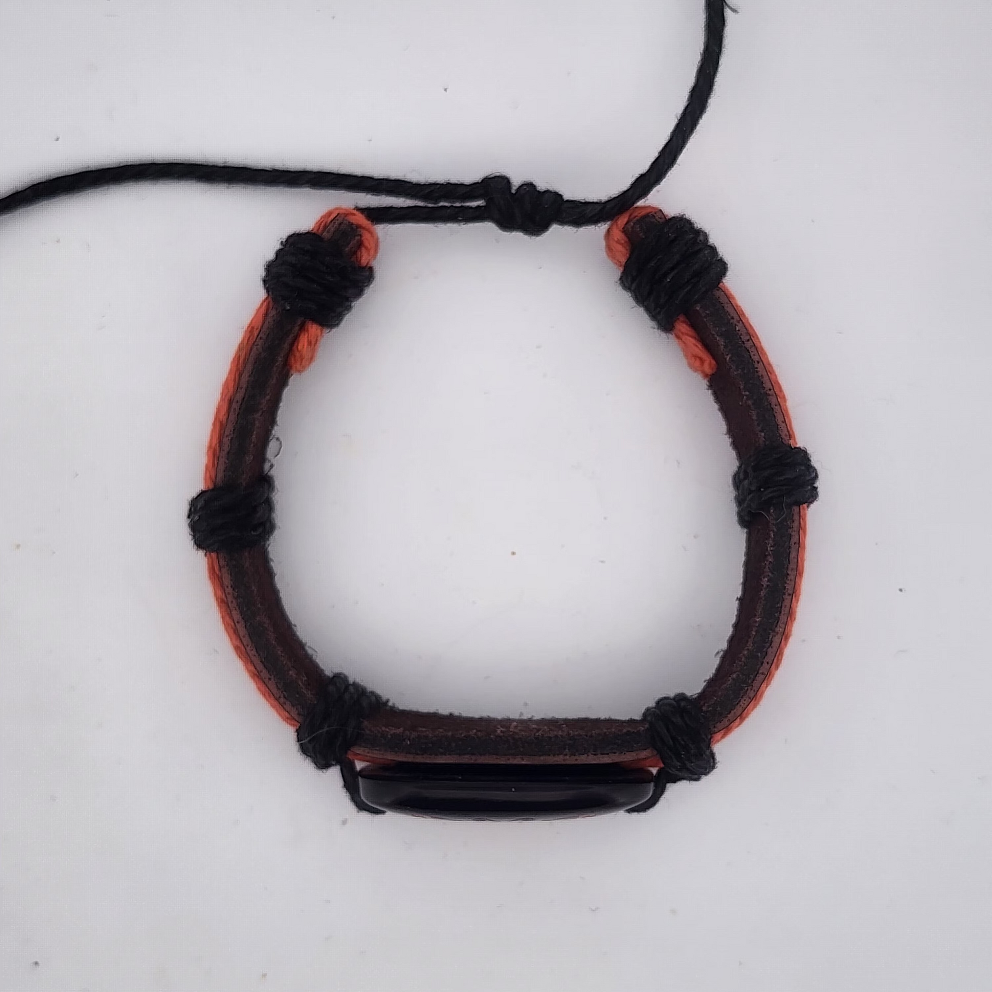 Bracelet with black and orange cord on a white background