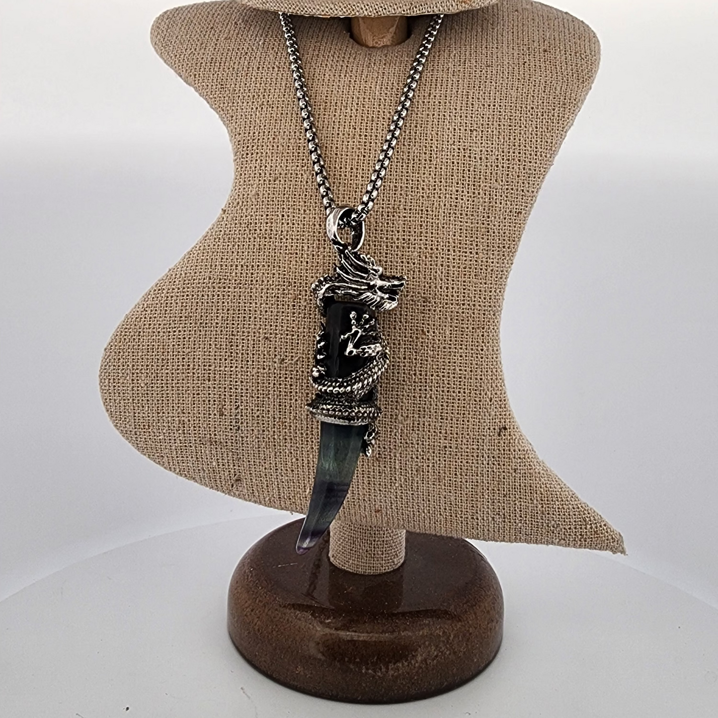 Necklace with a pendant on a mannequin bust against a plain background