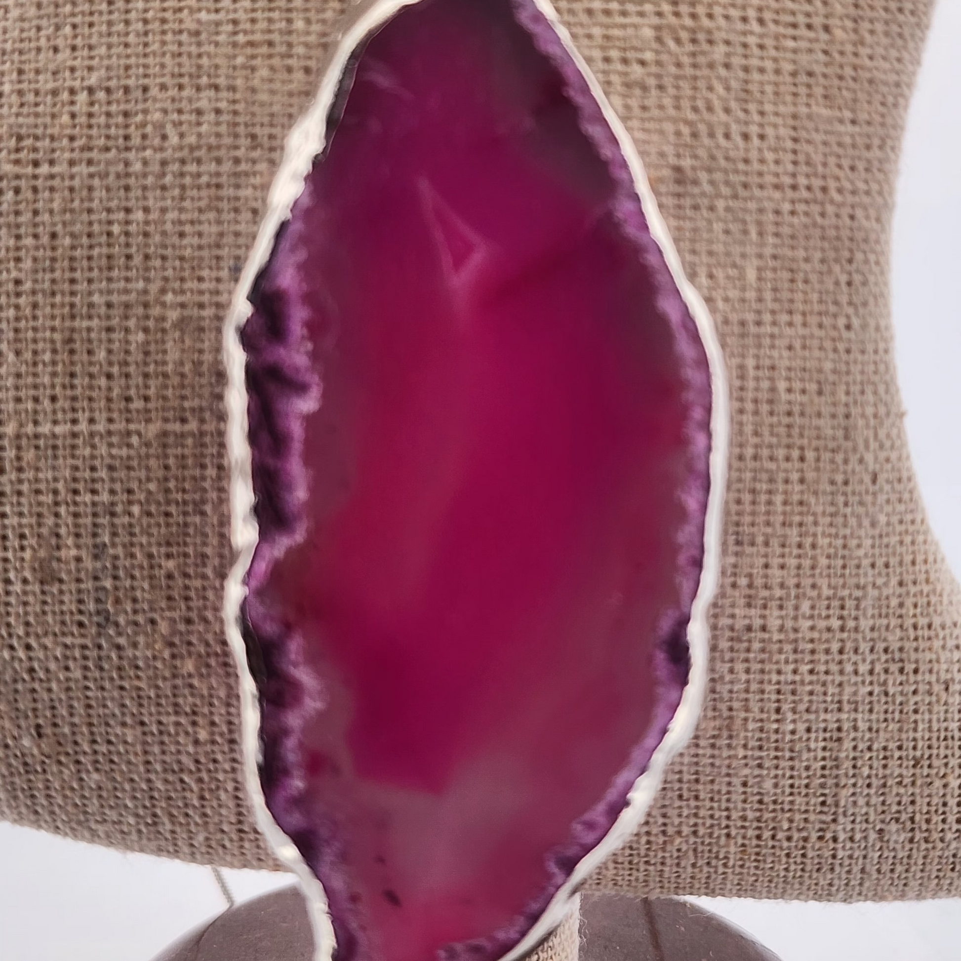 Purple geode pendant on a brown textured stand