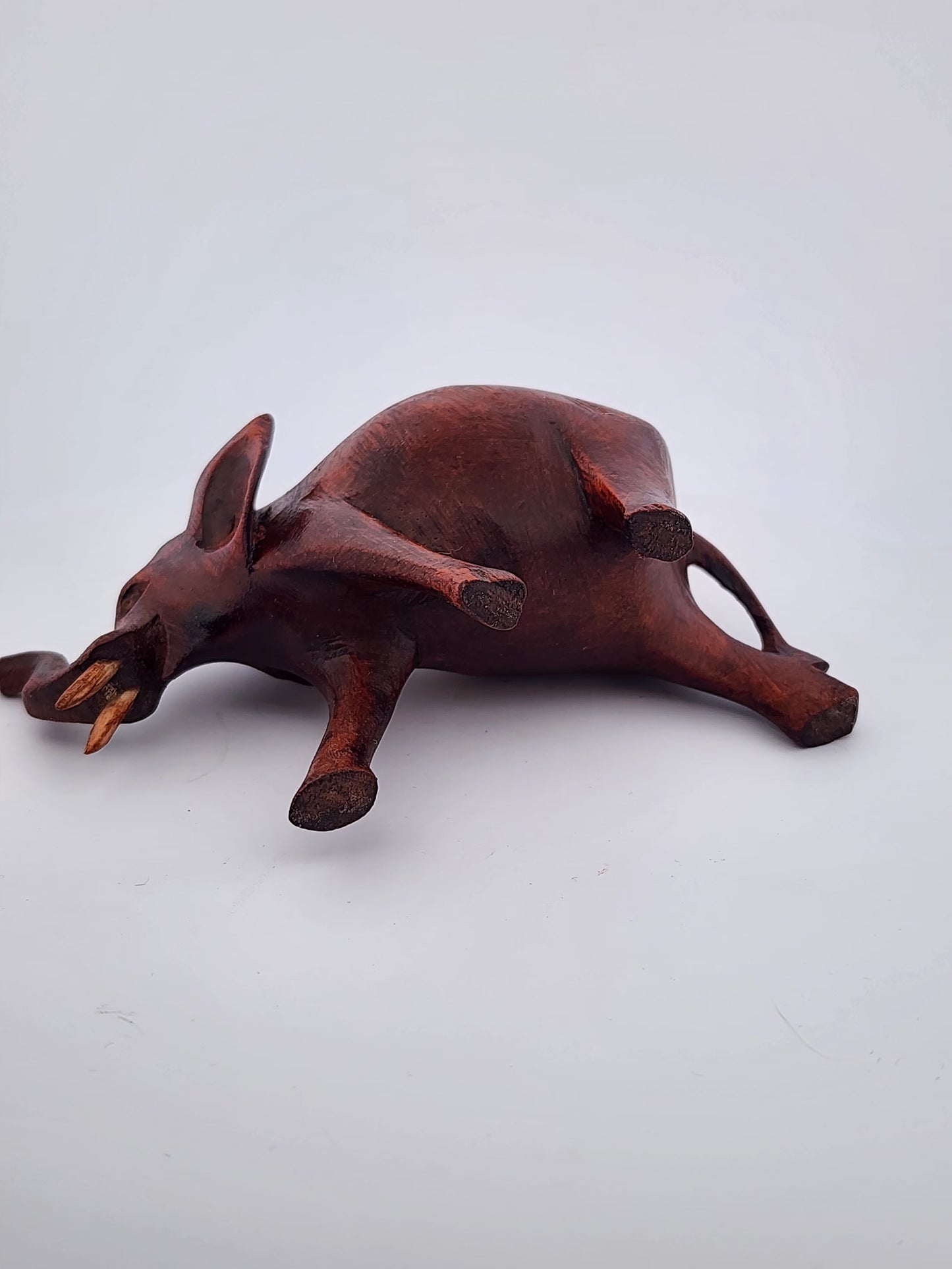 Wooden sculpture of a rodent on a white background