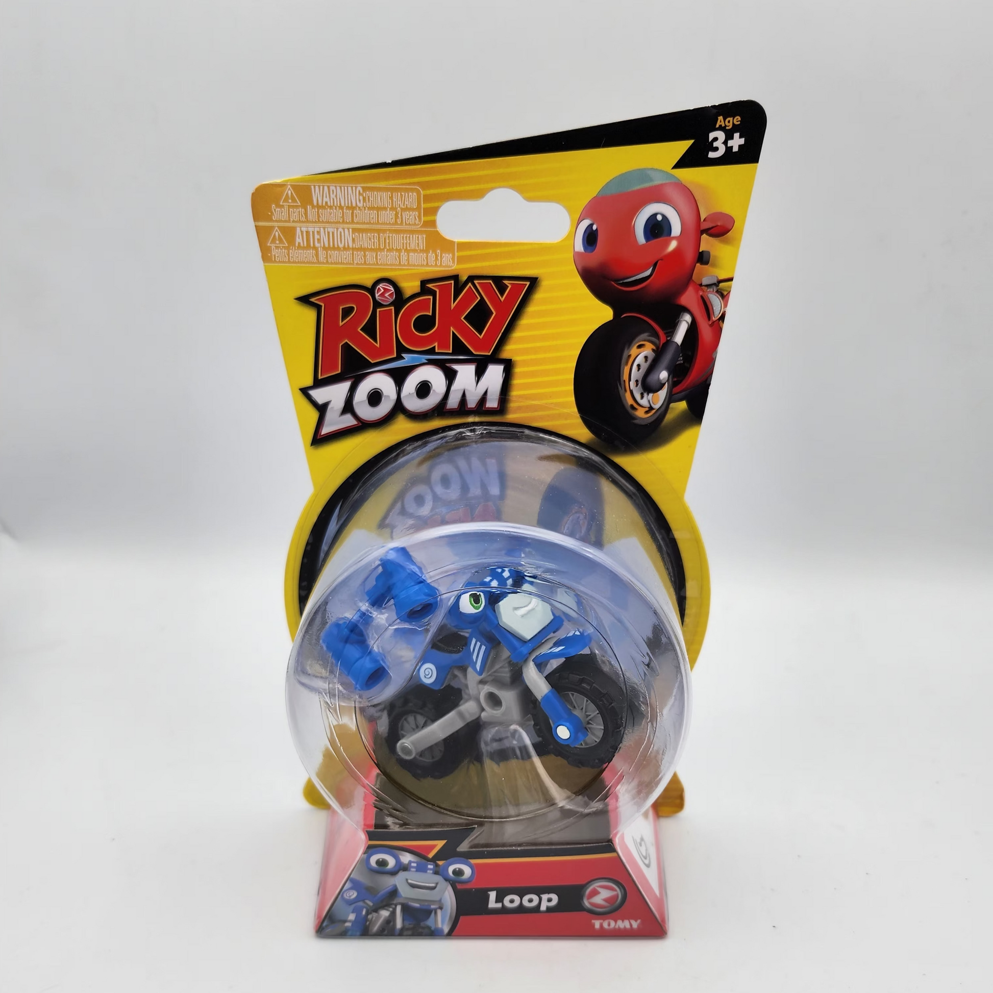 Toy figure in packaging with 'Ricky Zoom' branding on a white background