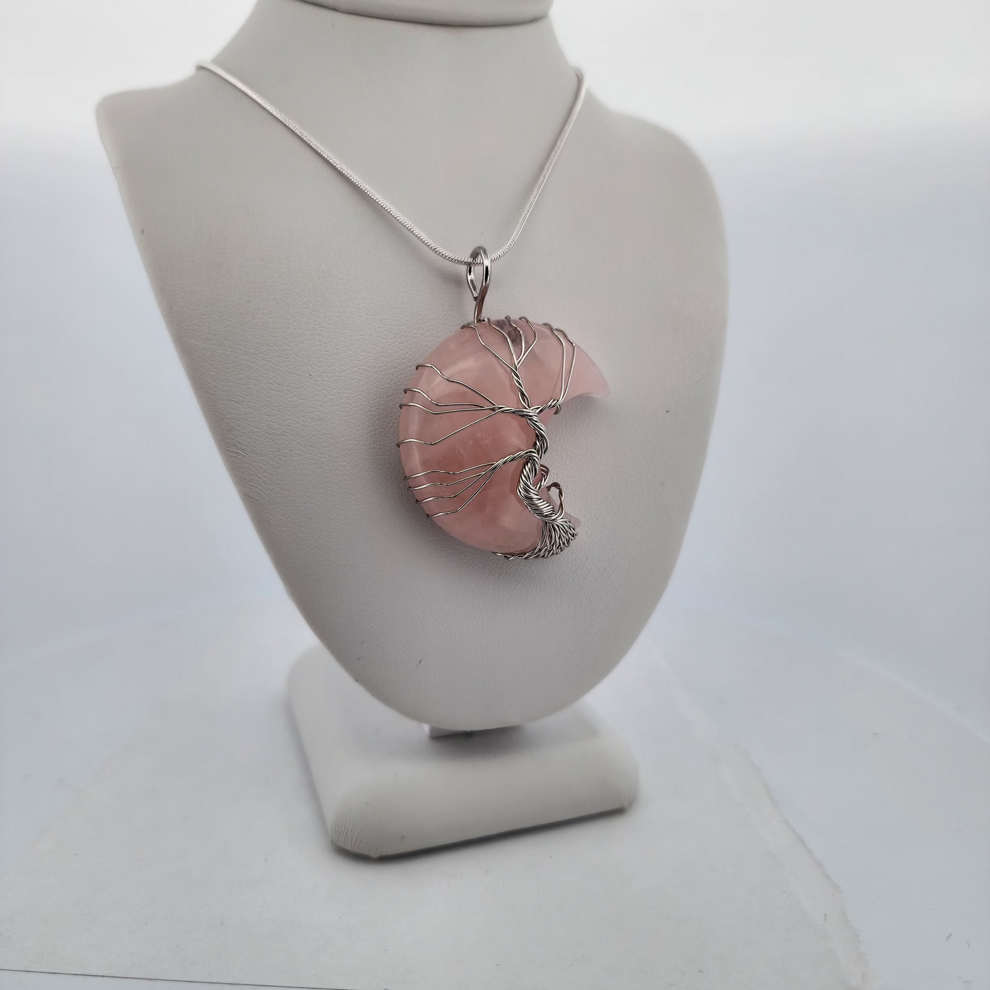 Necklace with a pink pendant on a white bust