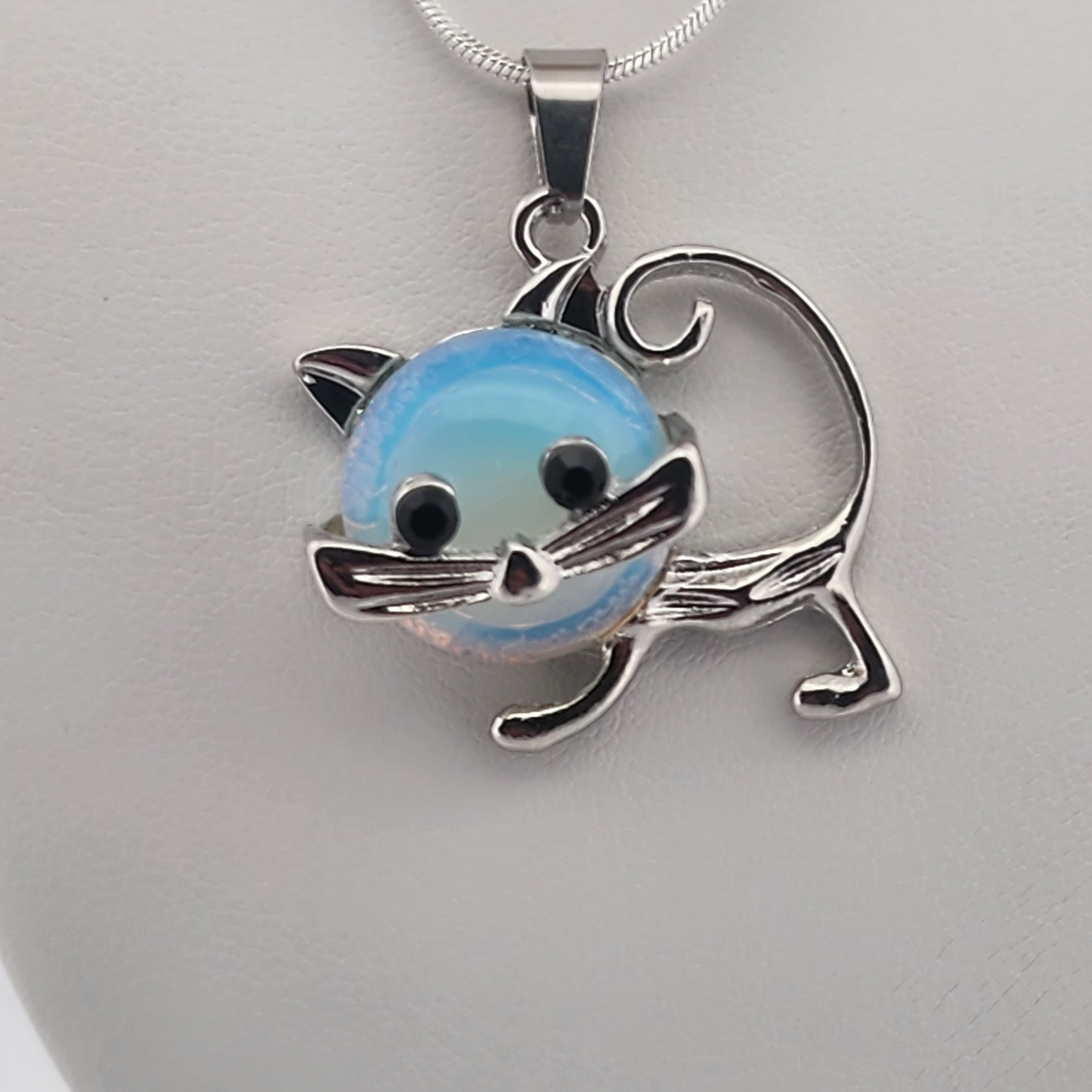 Cat-shaped pendant with a blue and white design on a gray background