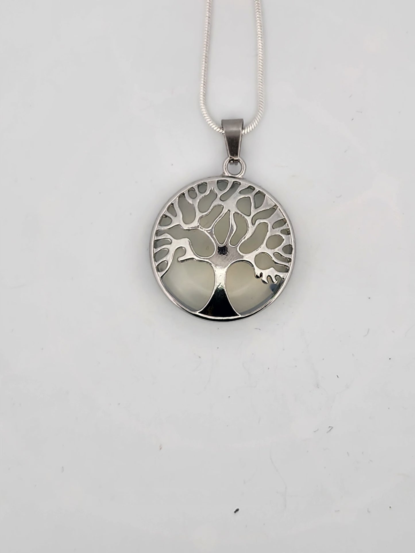 Silver tree of life pendant on a white background