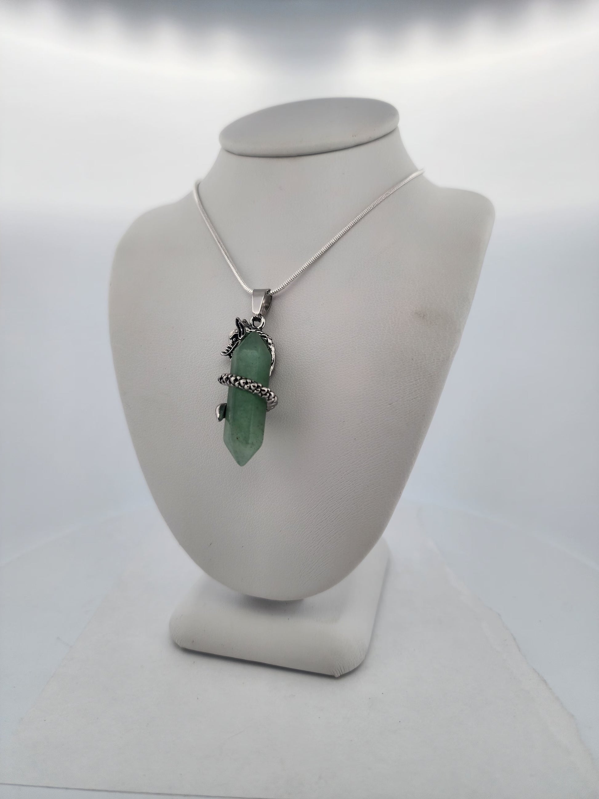 Necklace with a green pendant on a mannequin bust against a white background