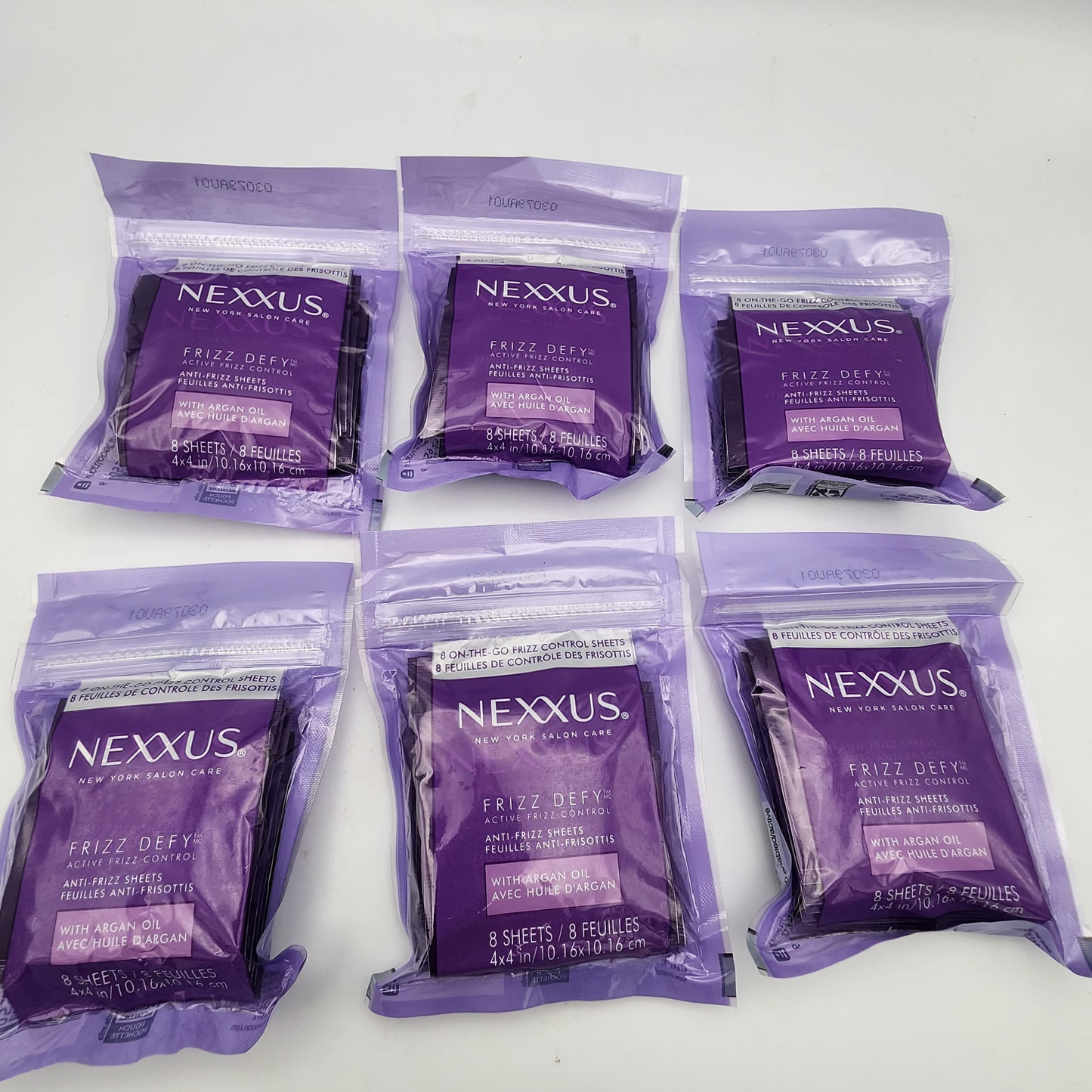 Multiple Nexxus hair care packets on a white background