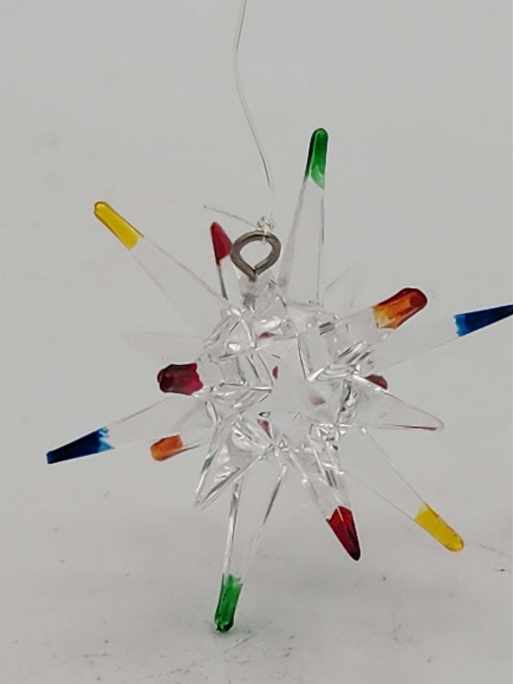 Decorative glass snowflake with colorful tips on a white background