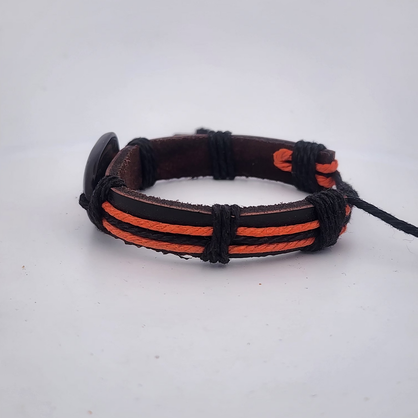 Bracelet with black and orange straps on a white background