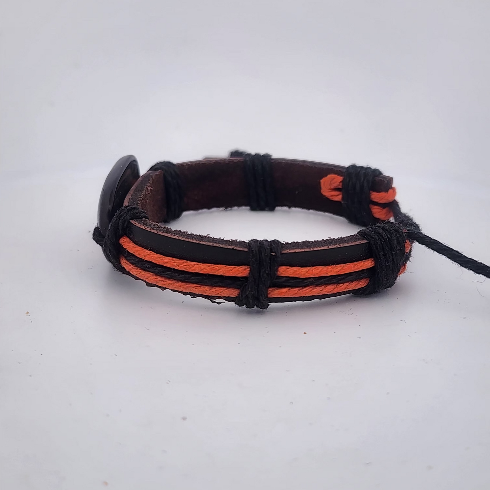 Bracelet with black and orange straps on a white background