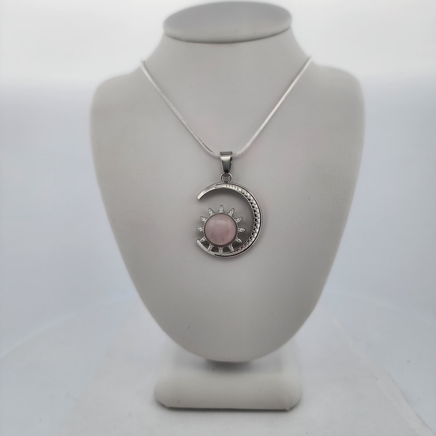 Necklace with a pink pendant on a mannequin bust against a white background