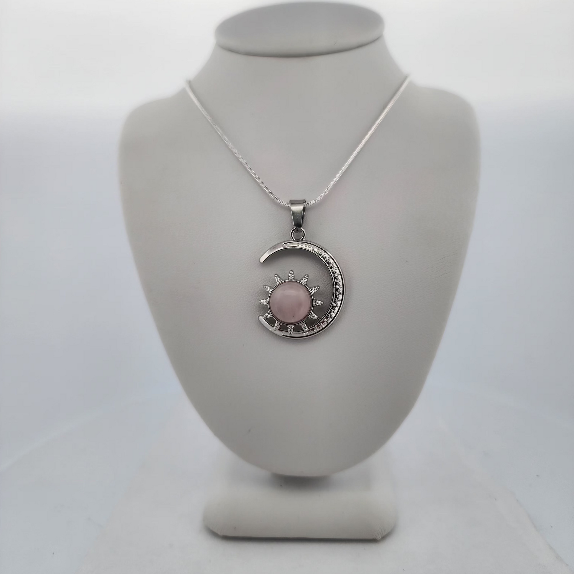 Necklace with a pink pendant on a mannequin bust against a white background