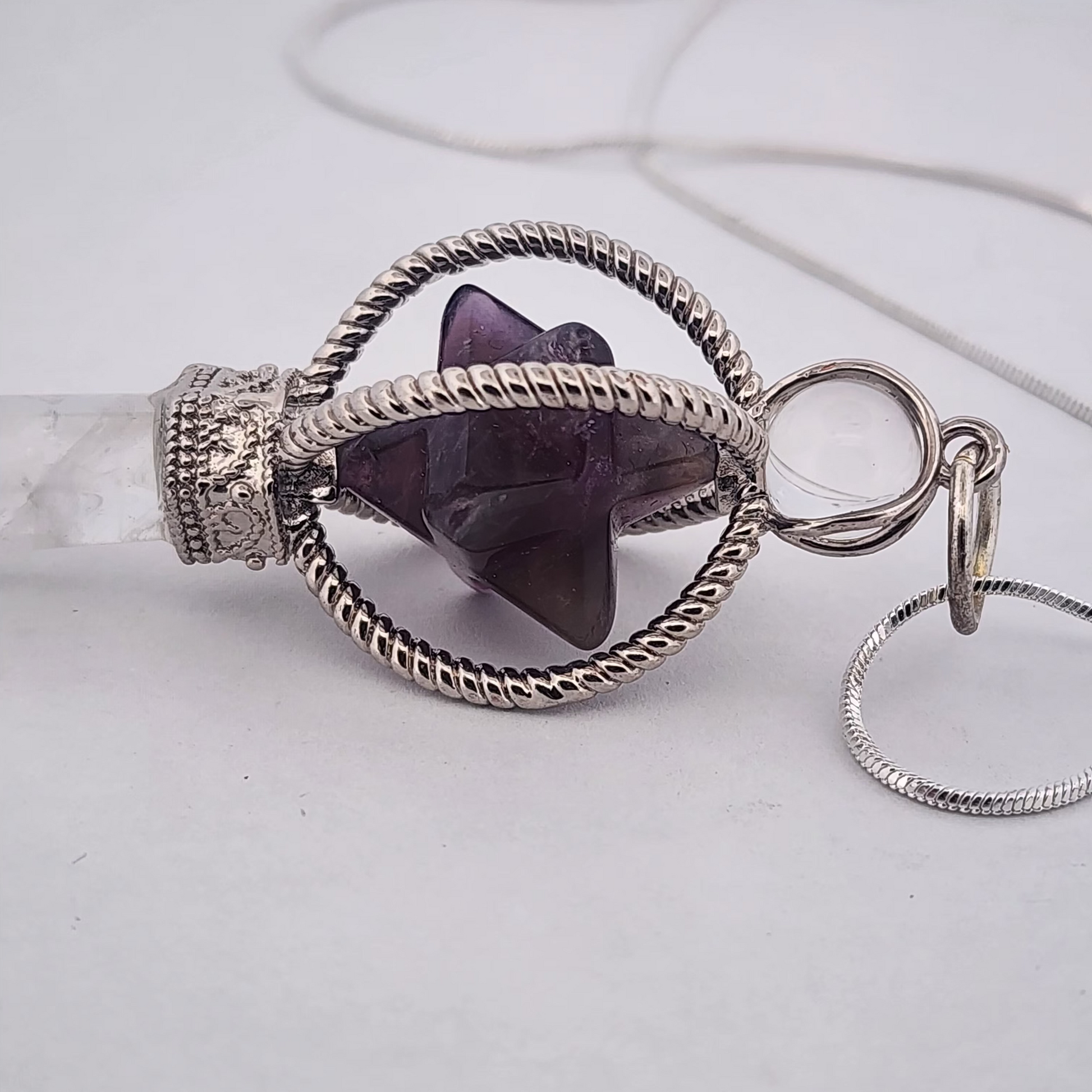 Necklace with a purple stone pendant on a light gray background