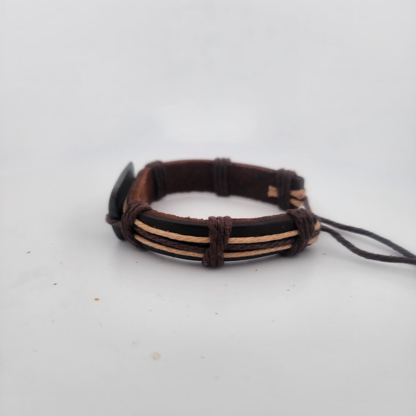 Brown leather bracelet on a light gray background