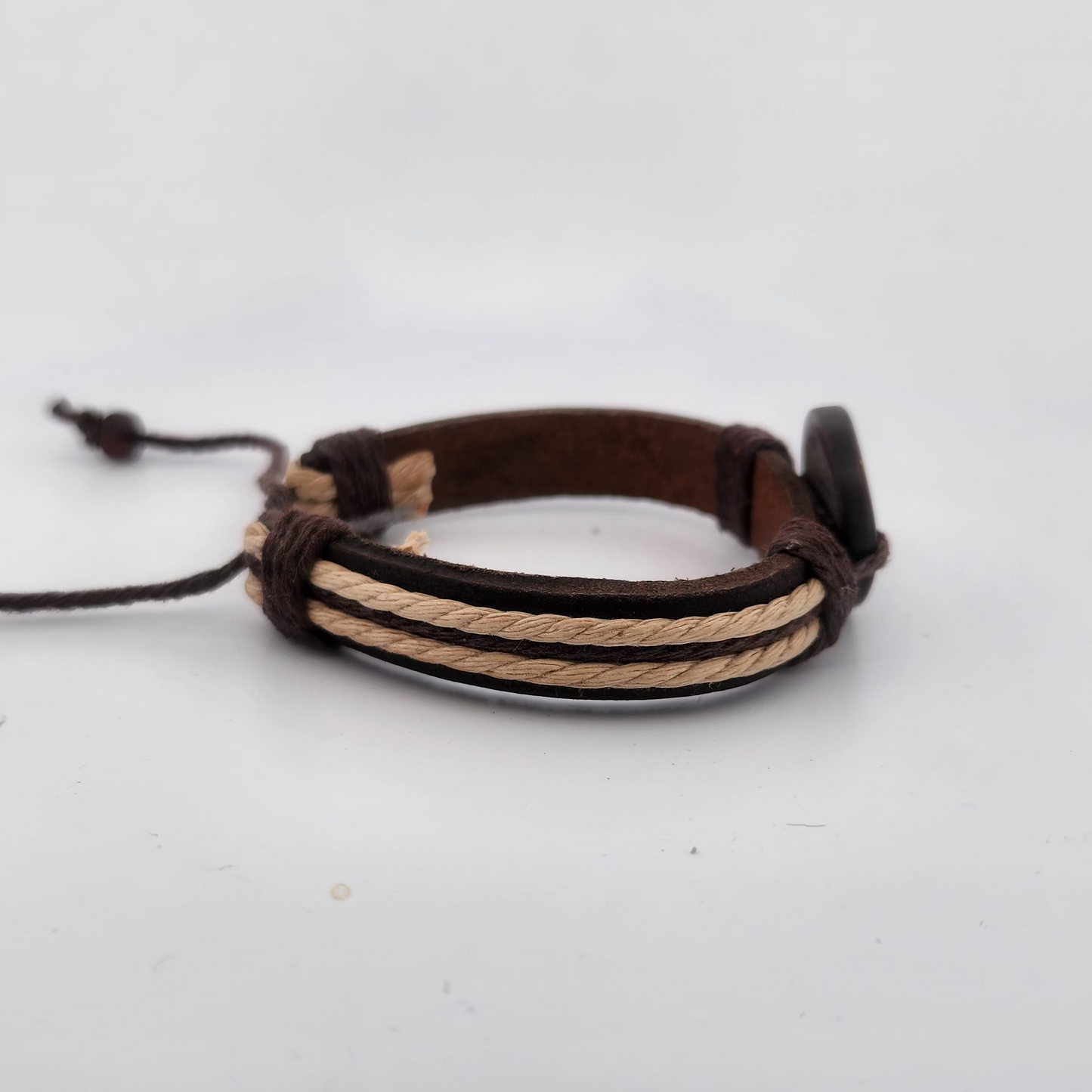 Multistrand leather and rope bracelet on a light gray background