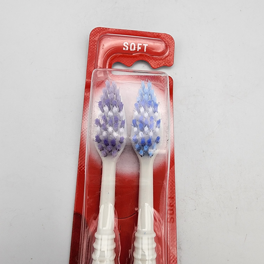 Two toothbrushes with blue bristles in a red packaging on a gray background