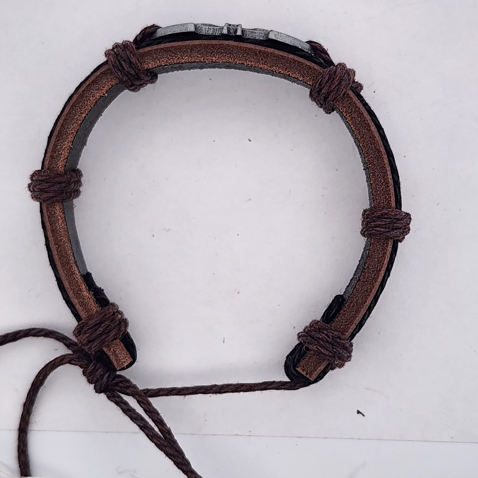 Brown leather bracelet with metal clasp on a white background