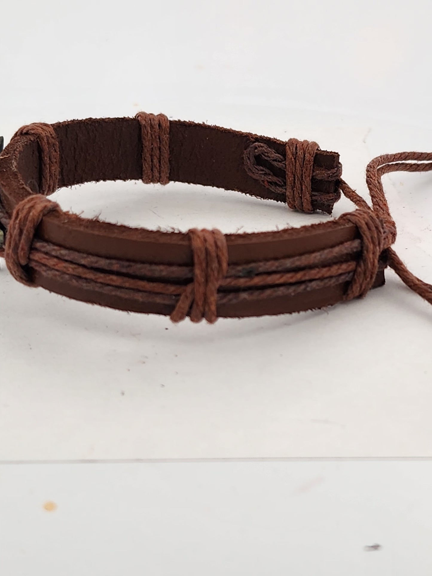 Brown braided leather bracelet on a white background