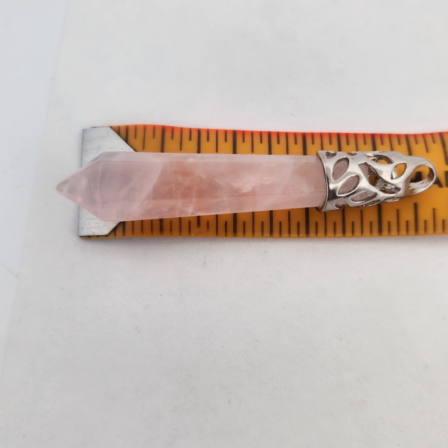  pink stone and silver design on a ruler for scale