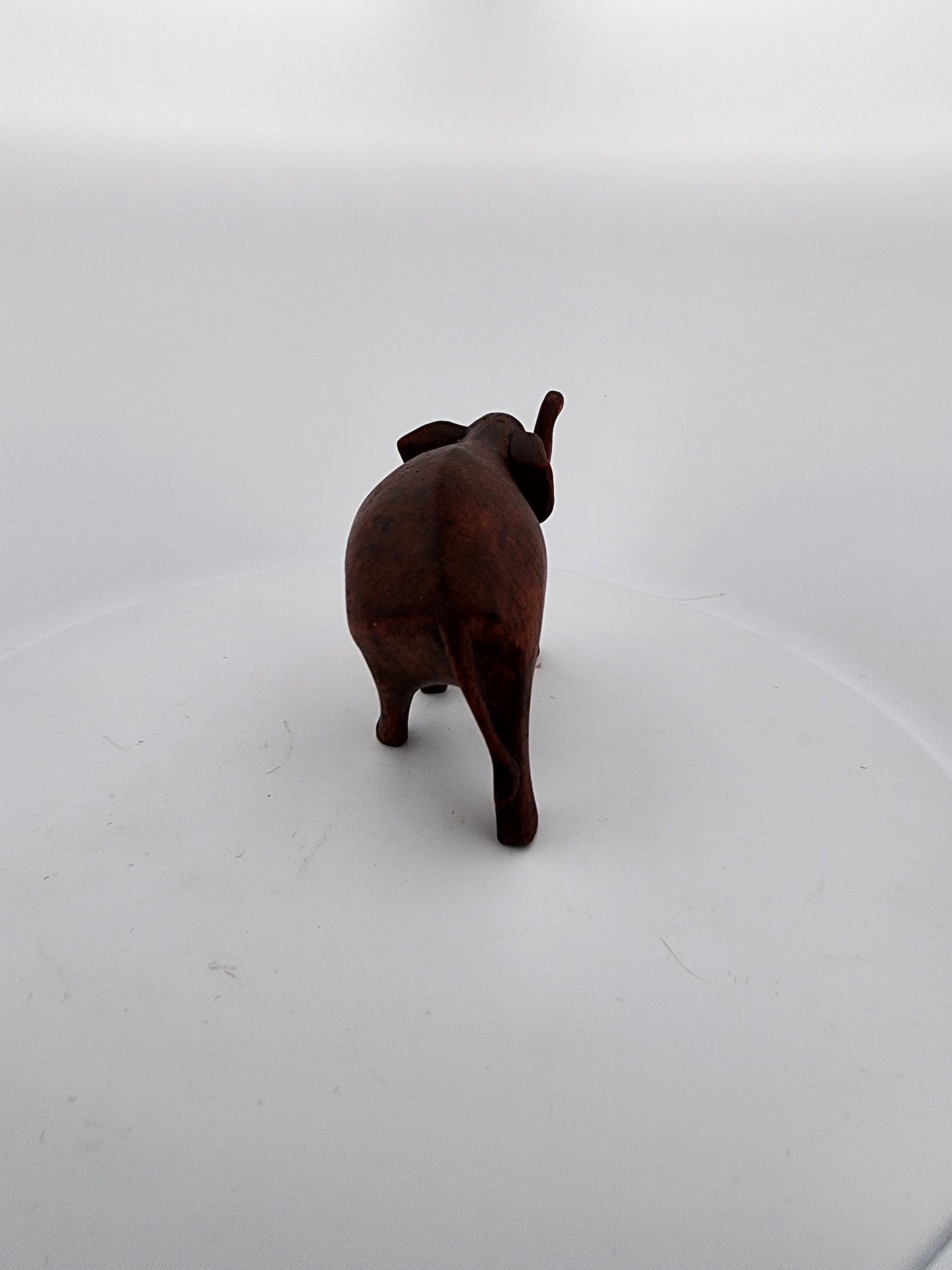 Small brown elephant figurine on a white background