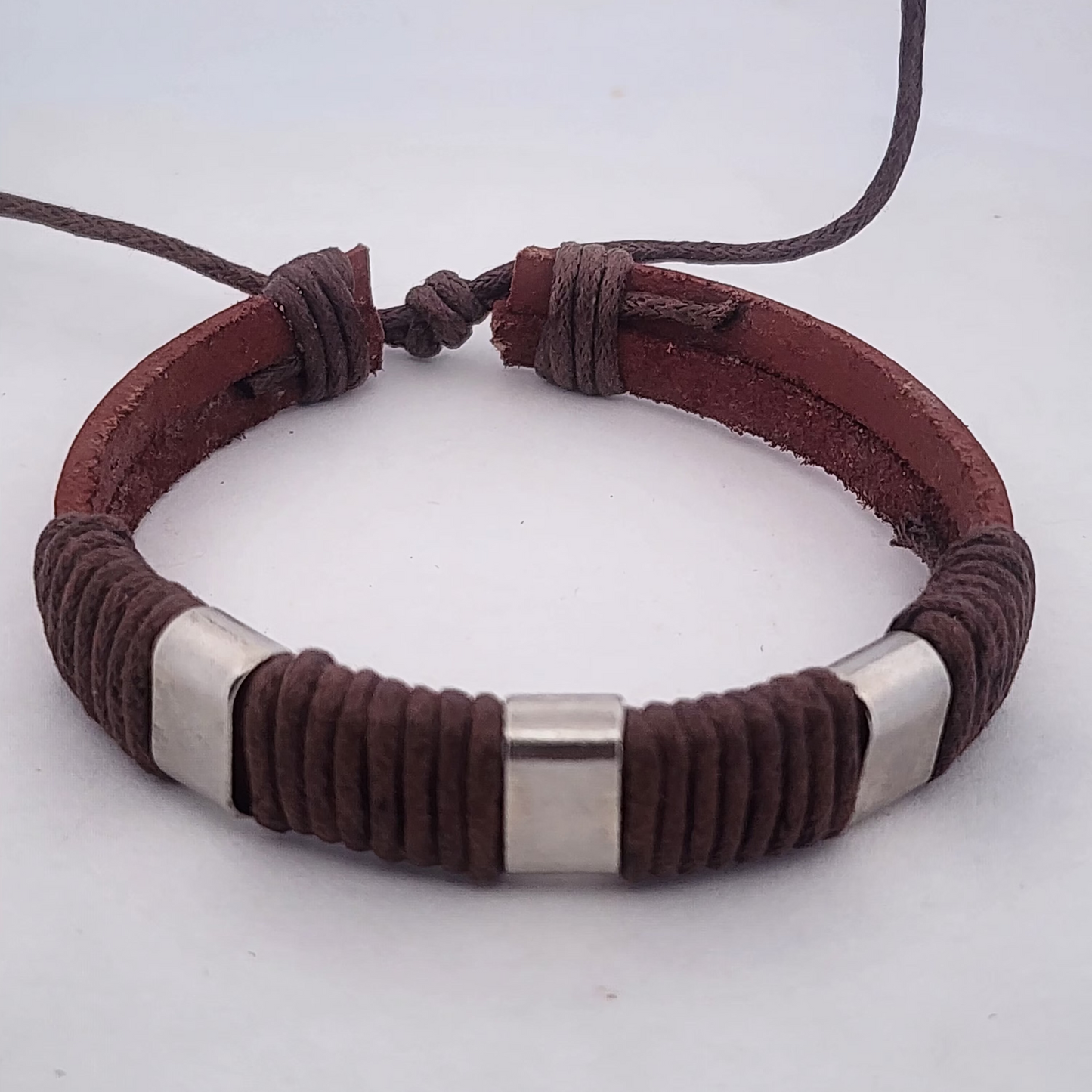 Brown leather bracelet with silver accents on a white background