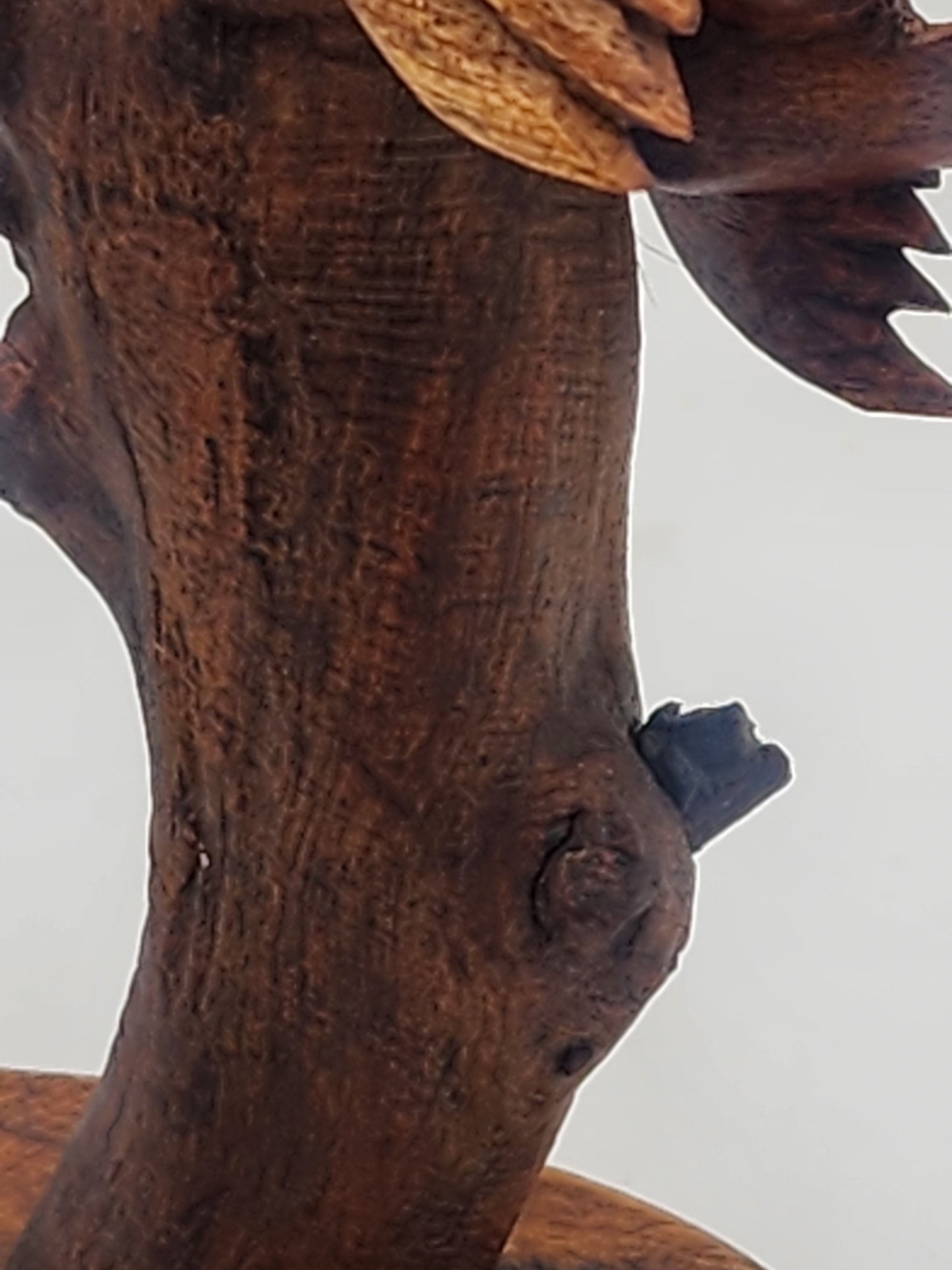 Close-up of a wooden Bird sculpture with detailed texture.