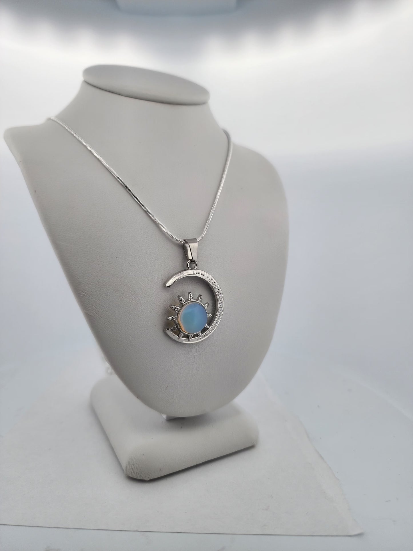 Silver necklace with a pendant on a mannequin bust against a white background