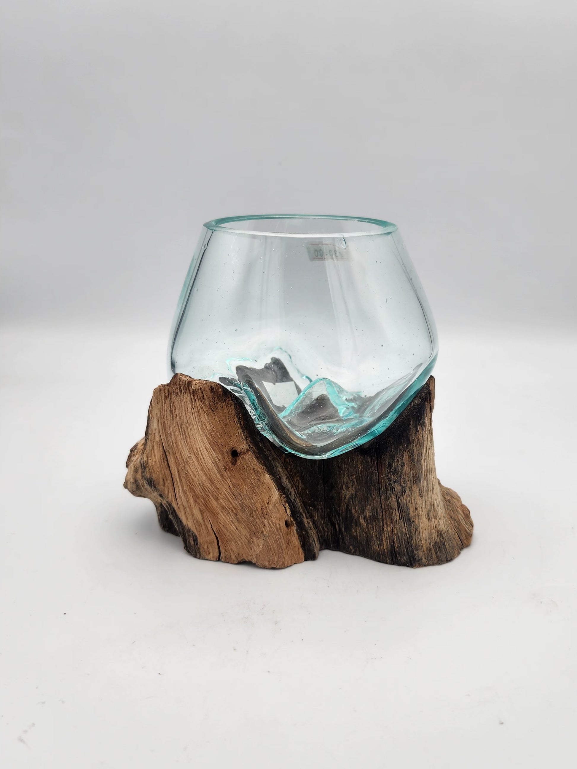 Clear glass vase on a wooden base against a white background