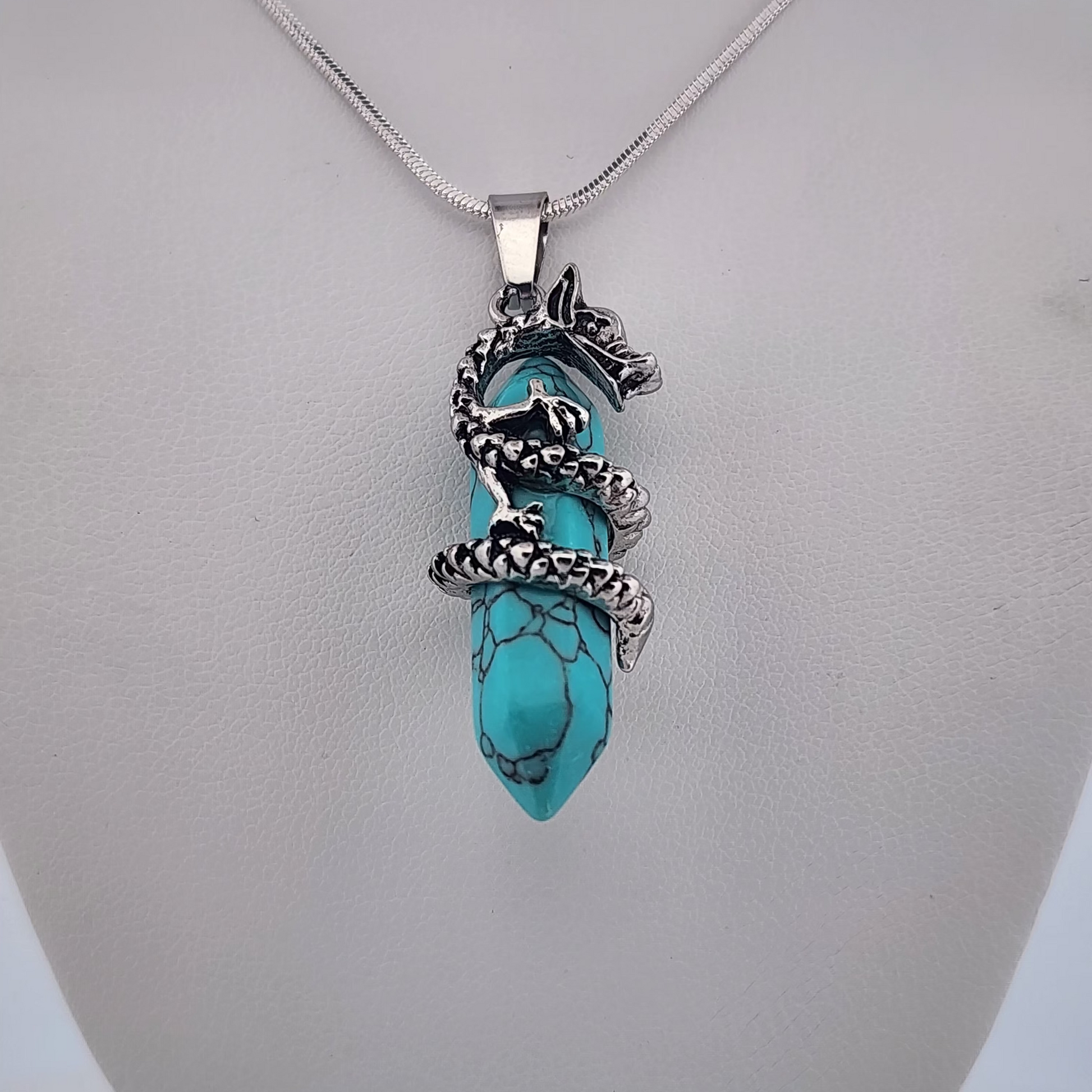 Turquoise pendant with silver chain on a mannequin bust