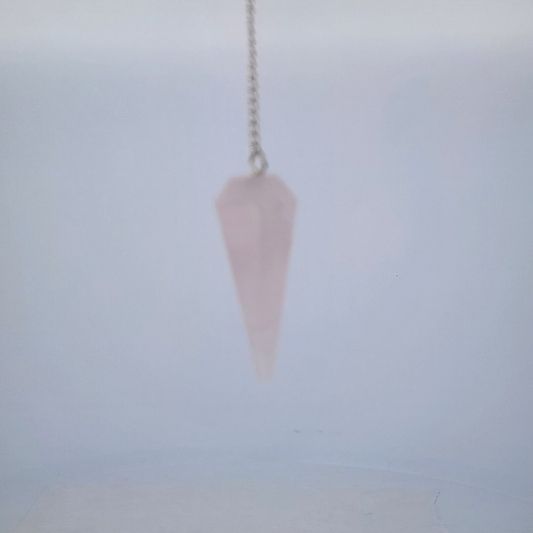 Pink crystal pendulum on a light gray background