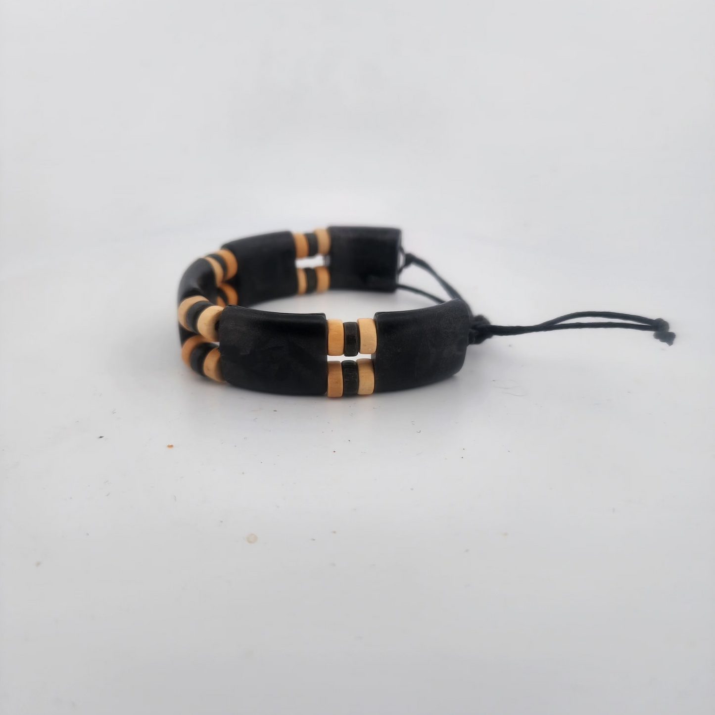 Black and gold beaded bracelet on a light gray background