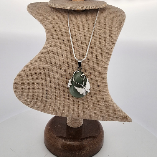 Necklace with a green pendant on a mannequin bust against a white background