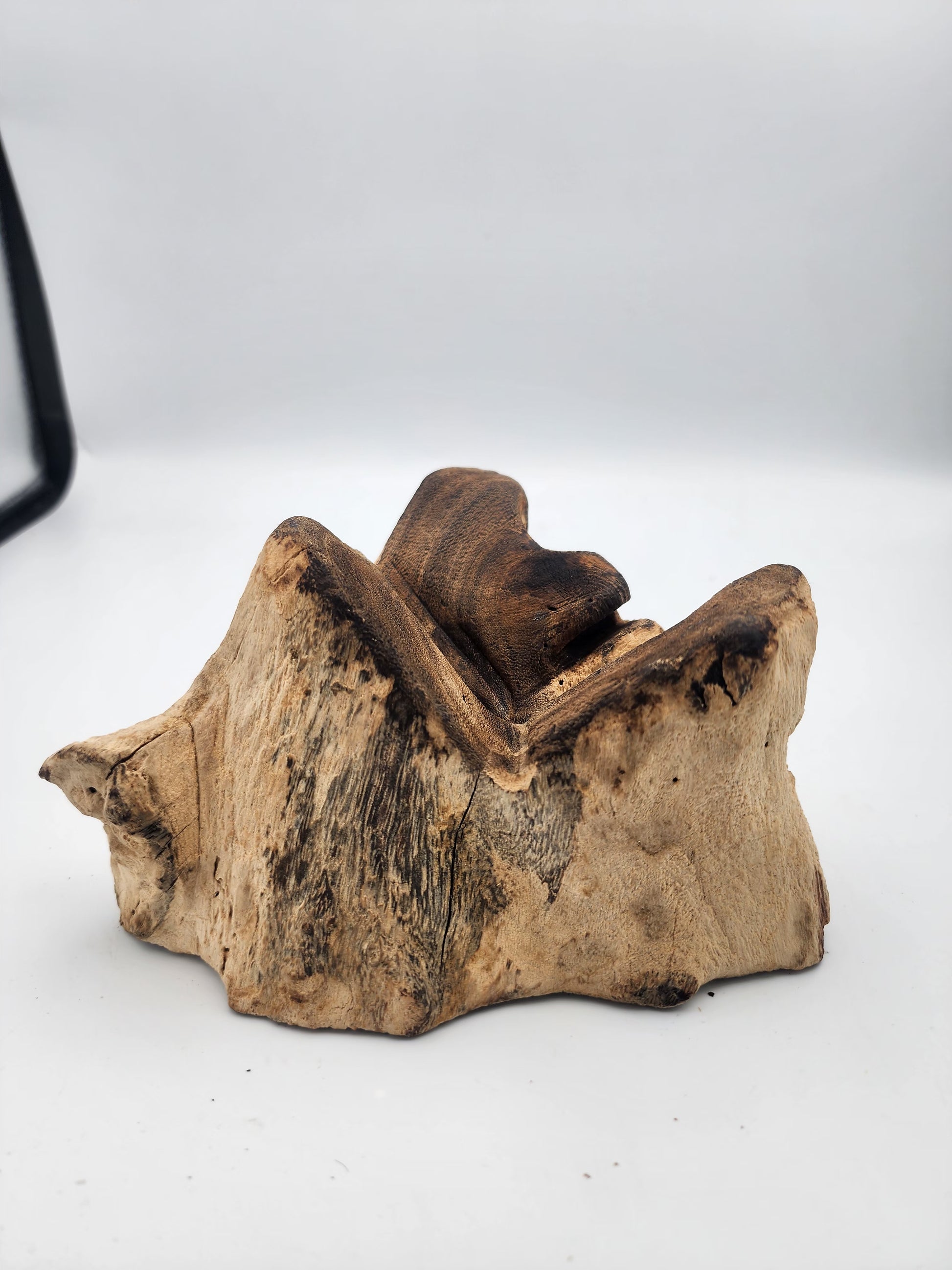 Wooden object resembling a chair on a white background