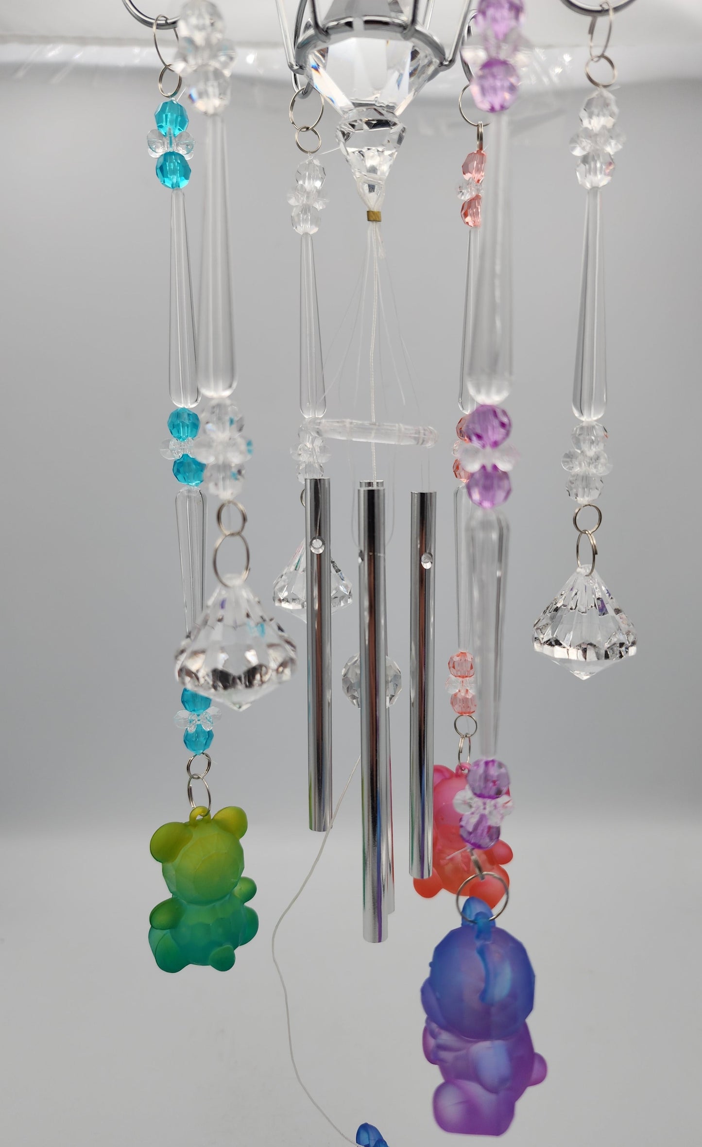Decorative hanging crystal with colorful beads against a plain background