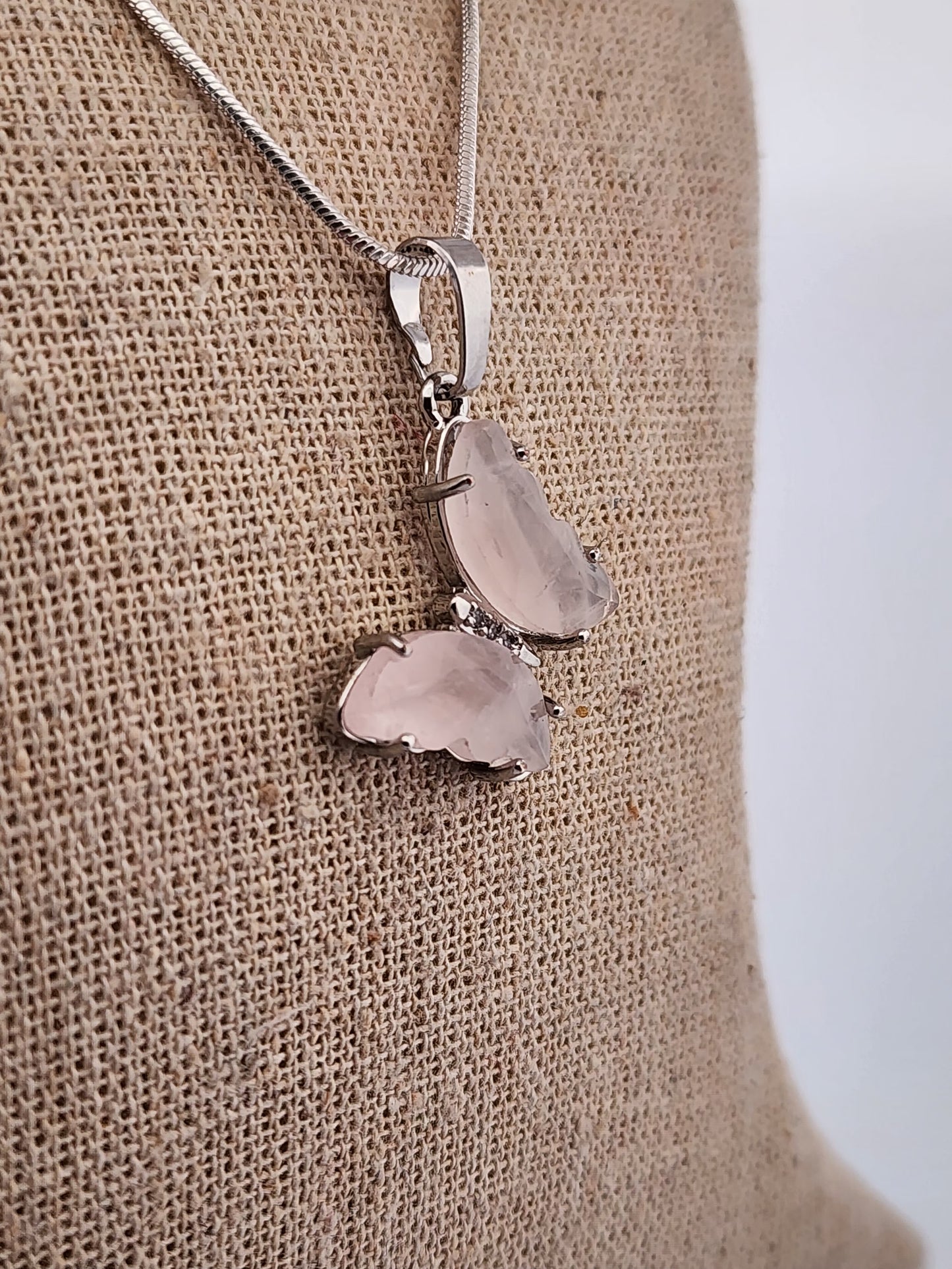 Silver necklace with a pendant on a beige fabric background