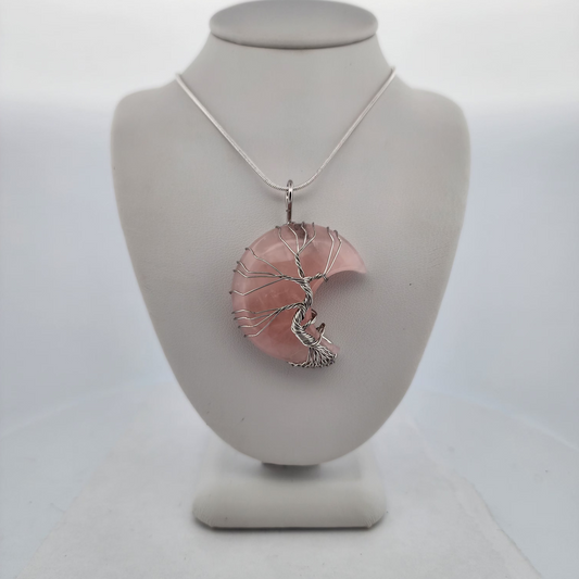 Necklace with a pink pendant on a white mannequin bust against a white background
