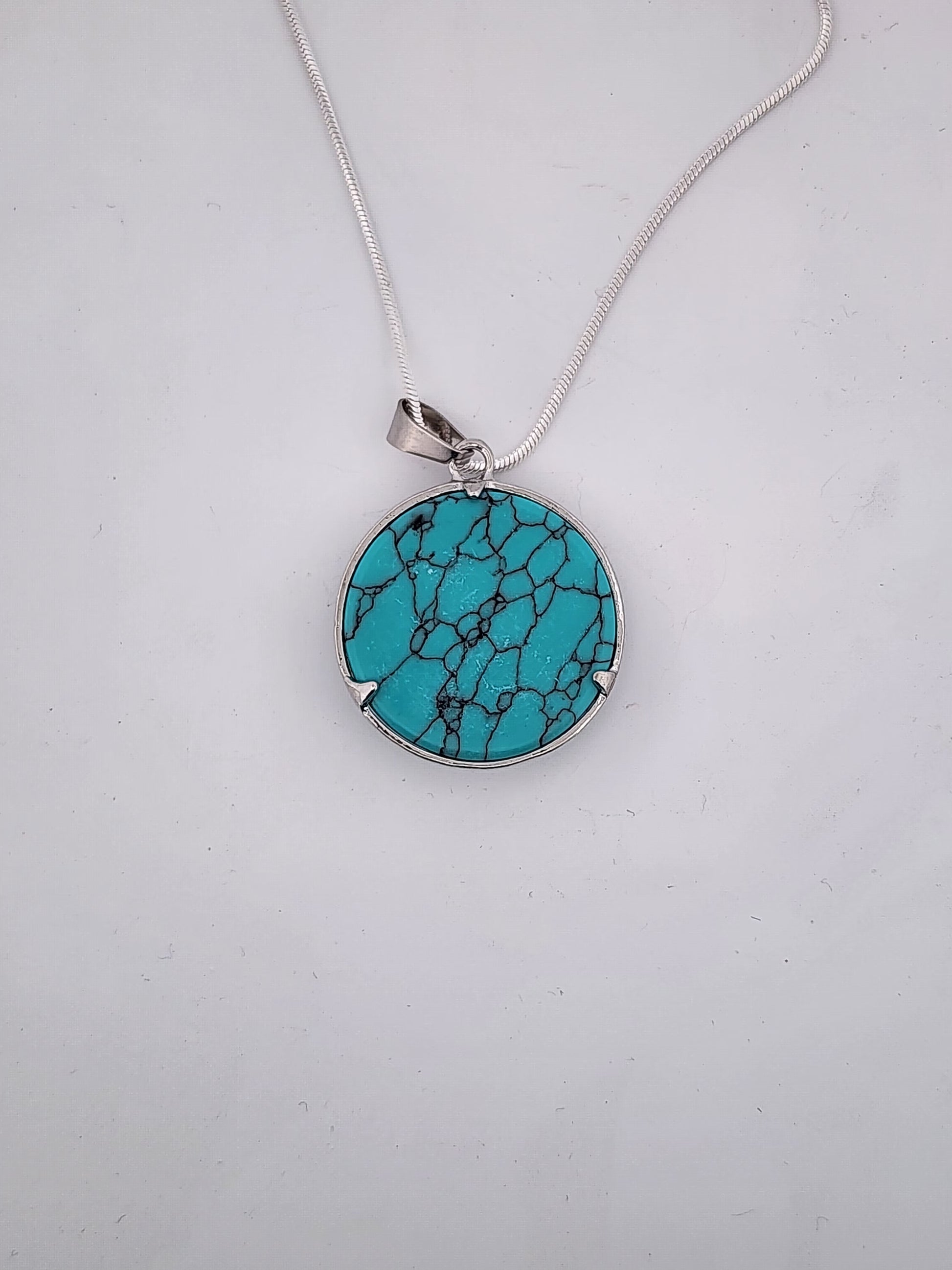 Turquoise pendant necklace on a white background